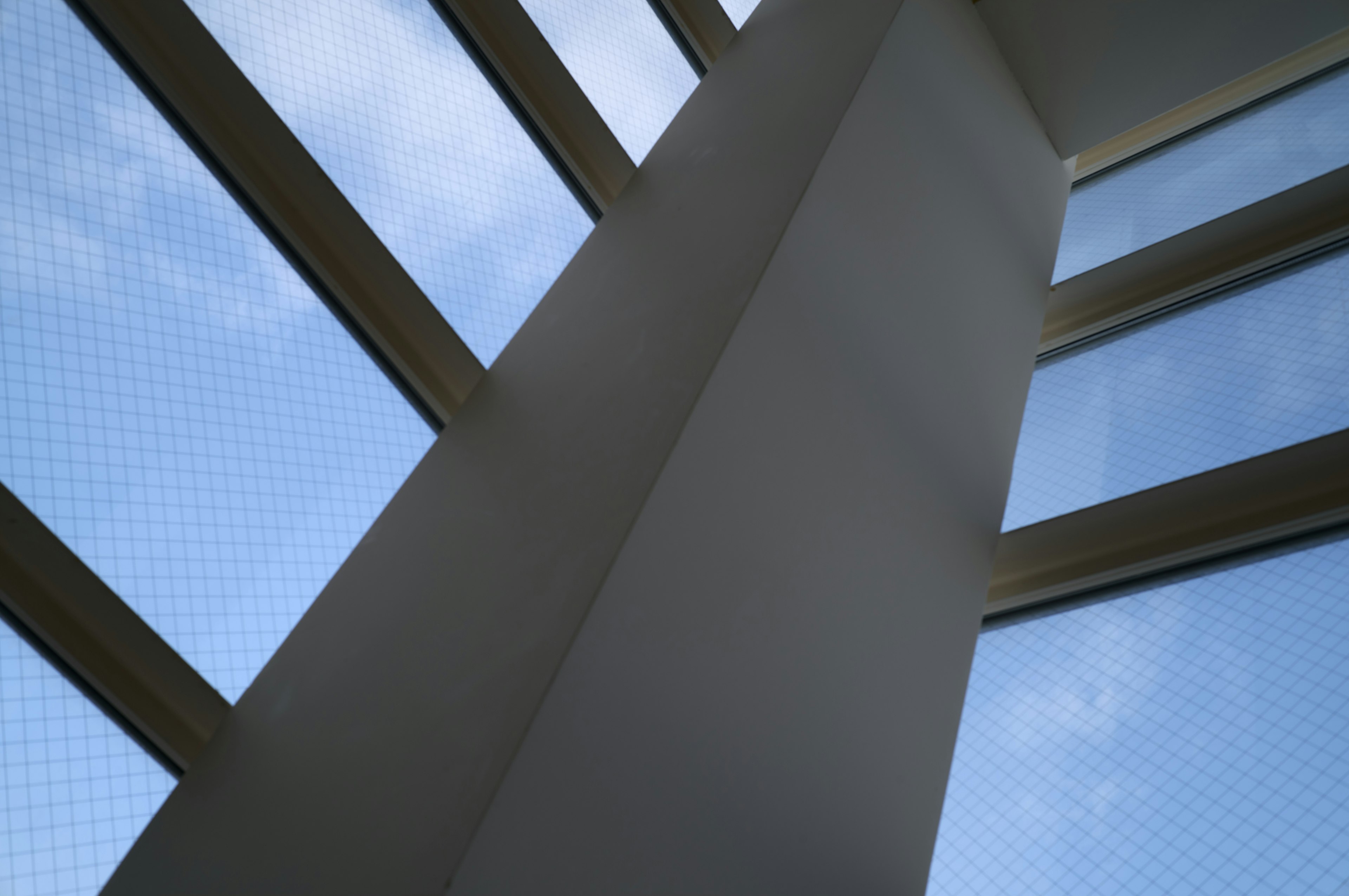 Esquina interior de un edificio con columna blanca y cielo azul