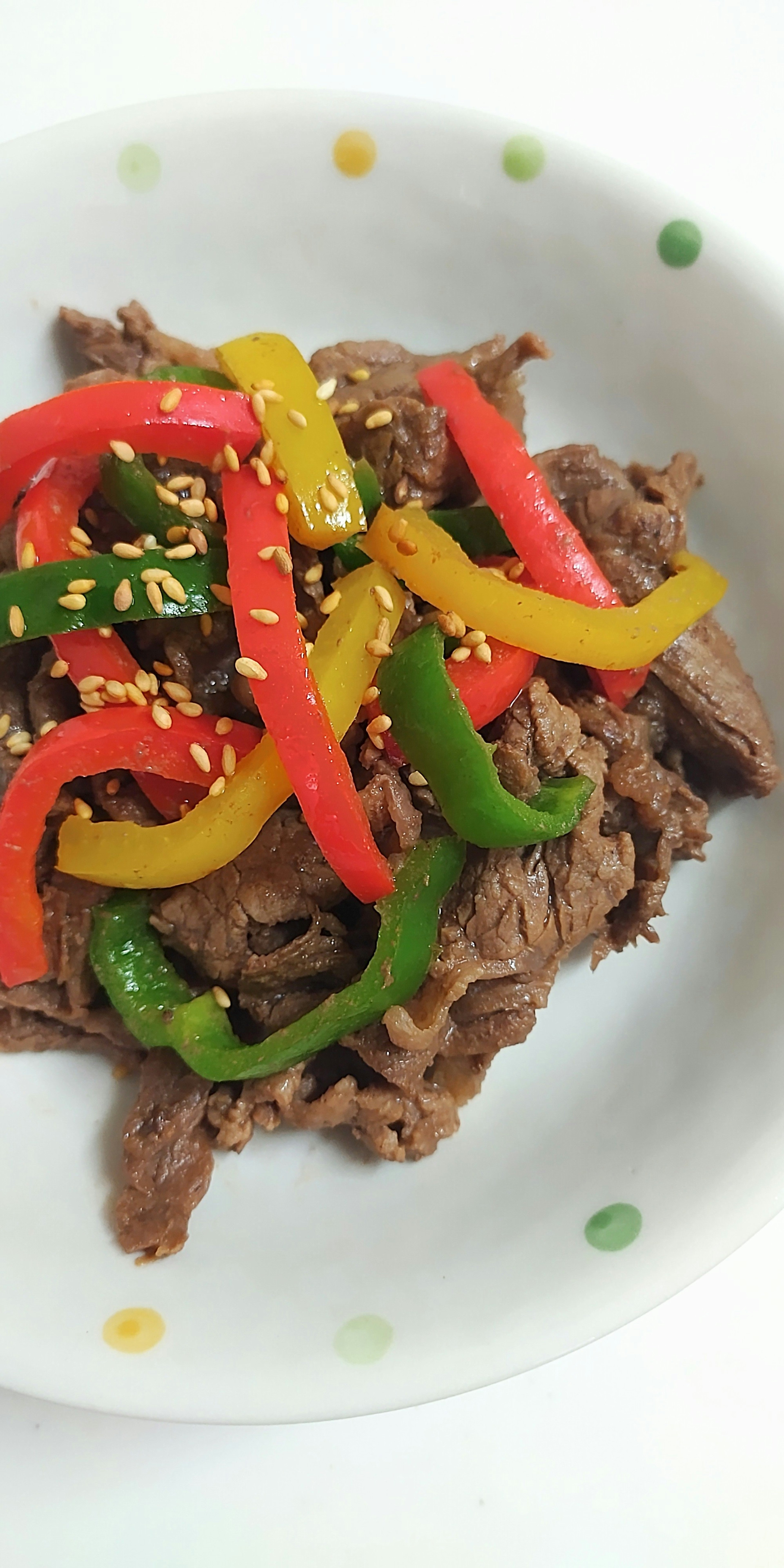 Plat de boeuf garni de poivrons colorés et de graines de sésame