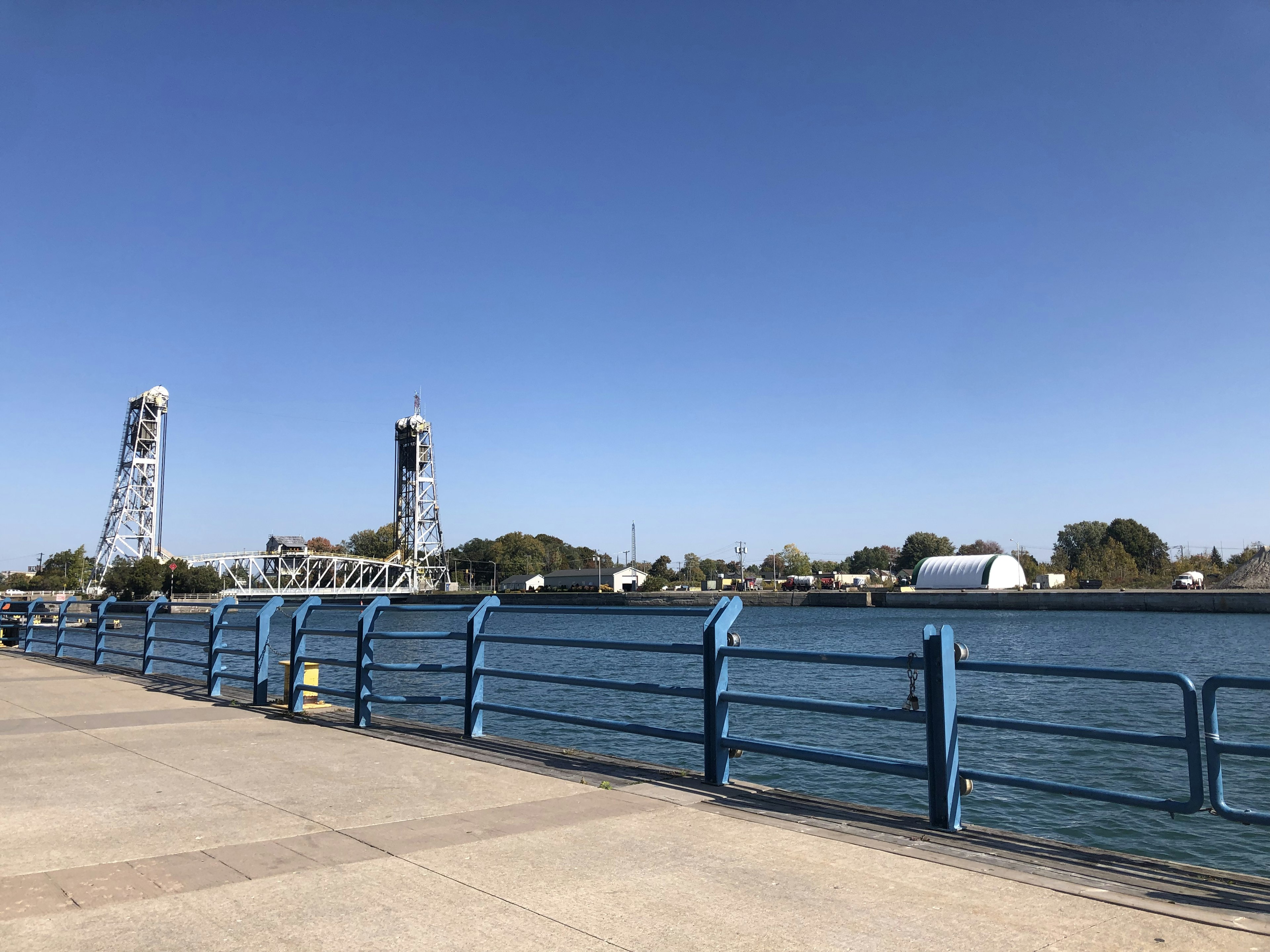 Vista escénica del waterfront con barandilla azul y torres del puente