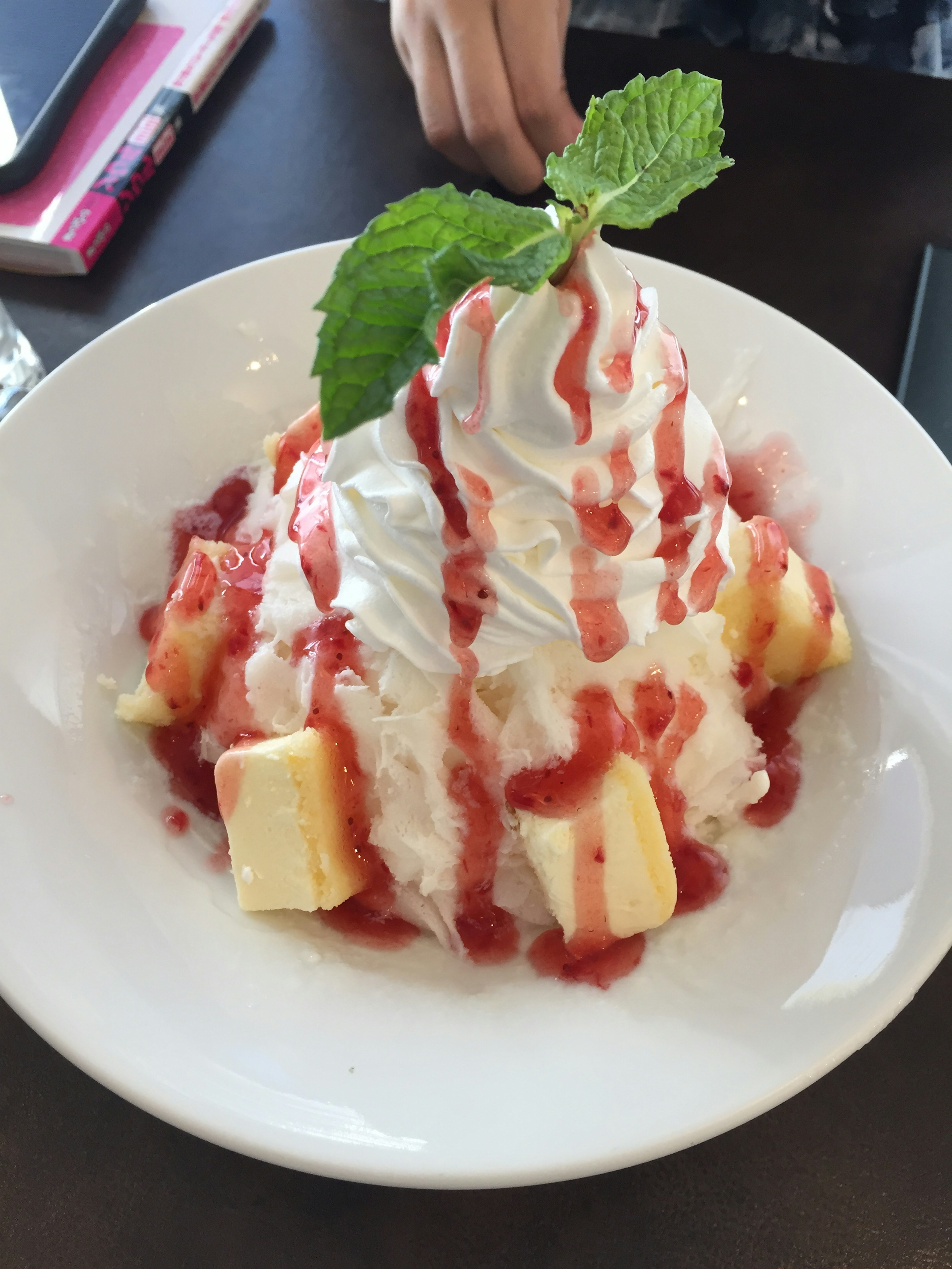 Dessert avec de la crème fouettée et de la sauce aux fraises sur des cubes