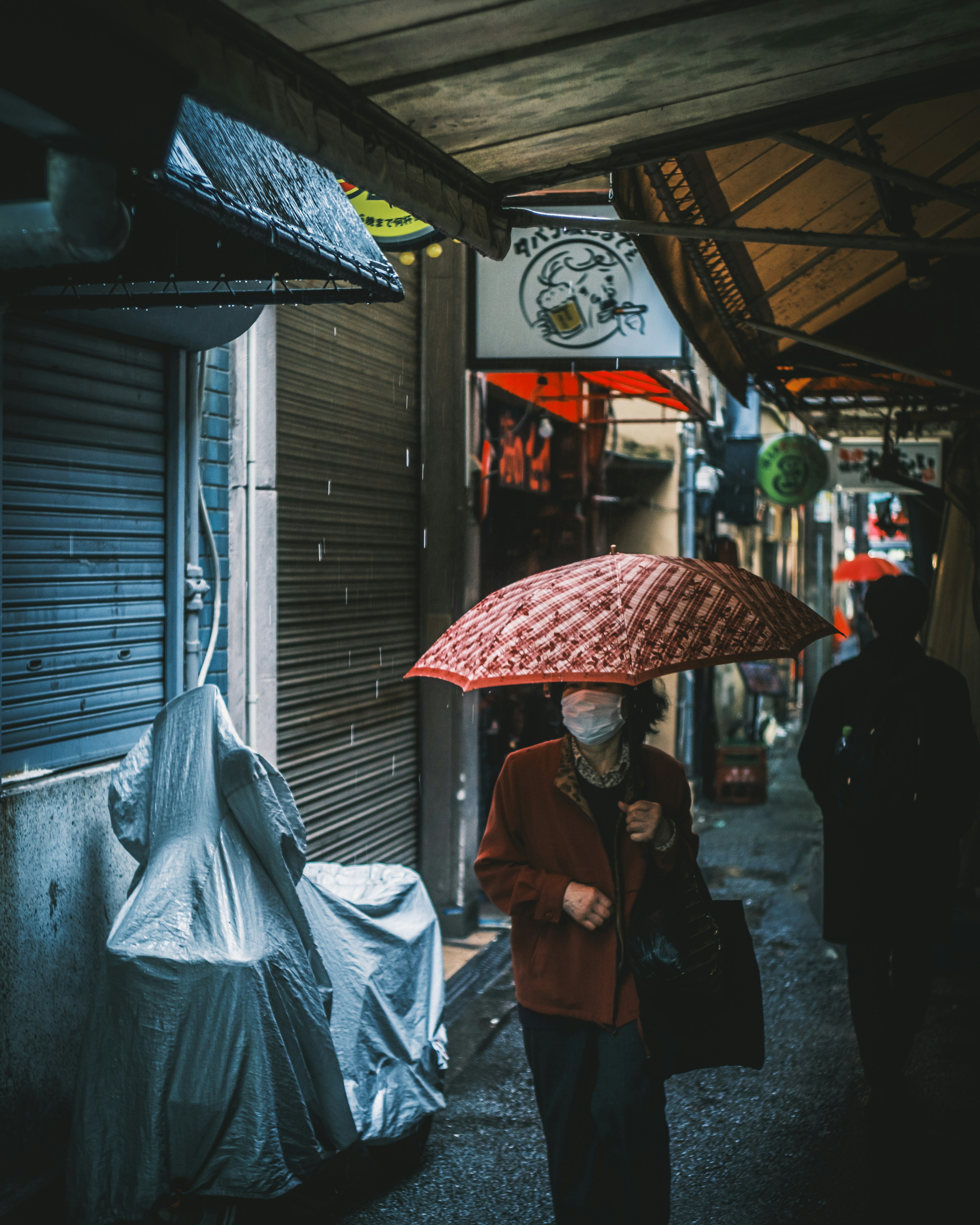 Scene of people walking in the rain with a red umbrella