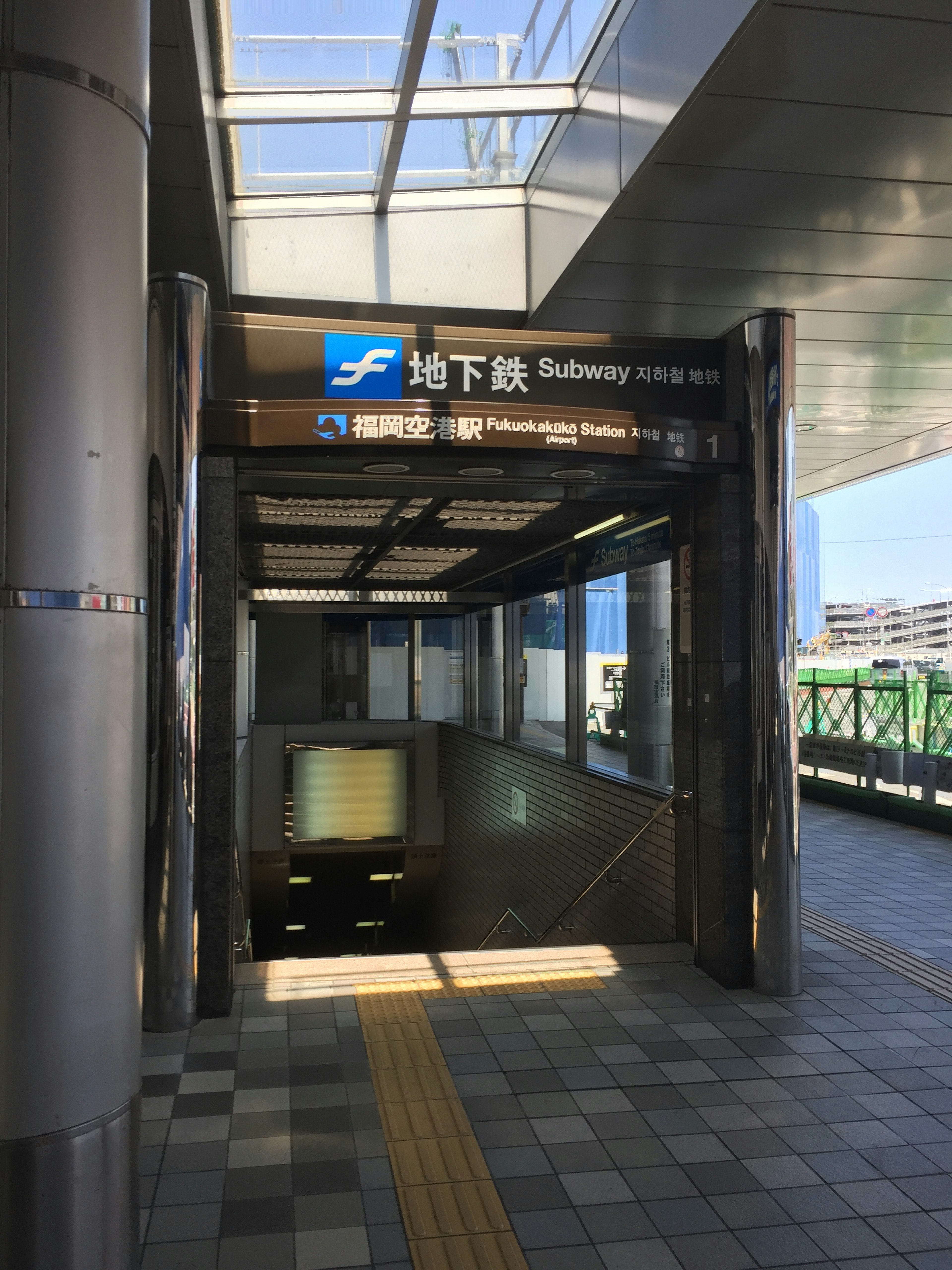 Bright view of a subway entrance with signage