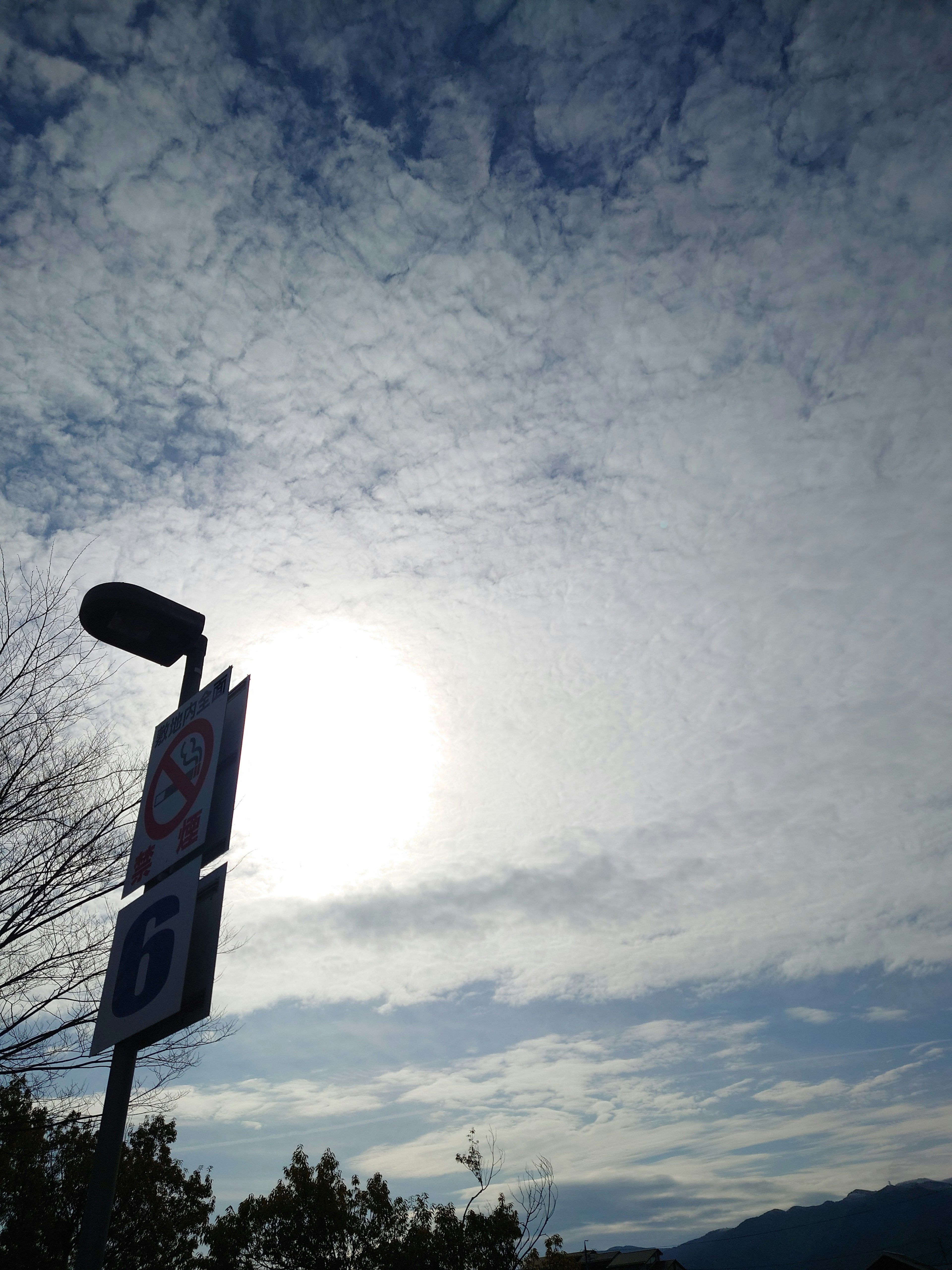 Bild eines Schildes mit Wolken und Sonnenlicht im Hintergrund