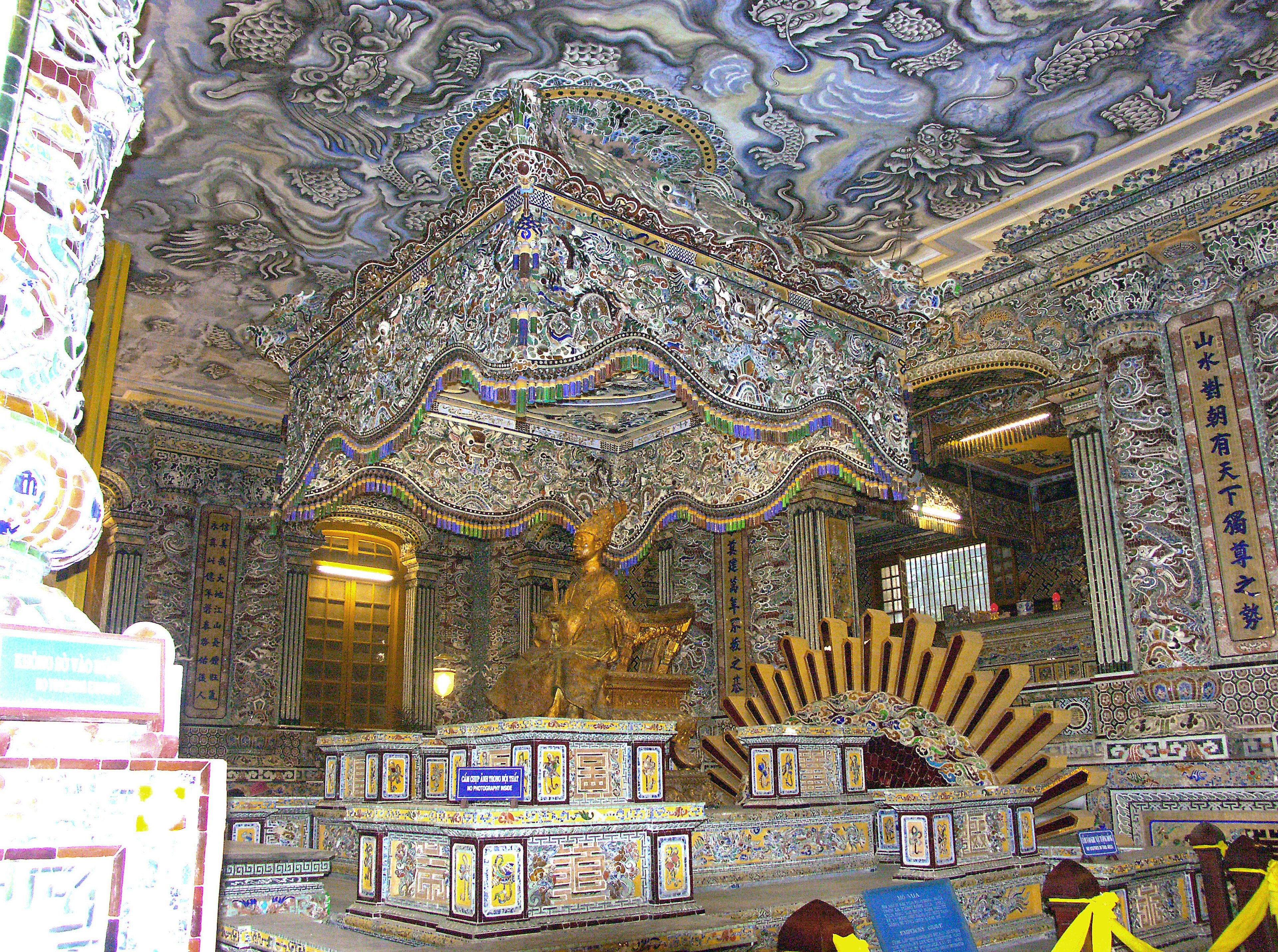 Interior intrincado de un templo con decoraciones ornamentadas Patrones elaborados en paredes y techo Estatua dorada de Buda en el centro