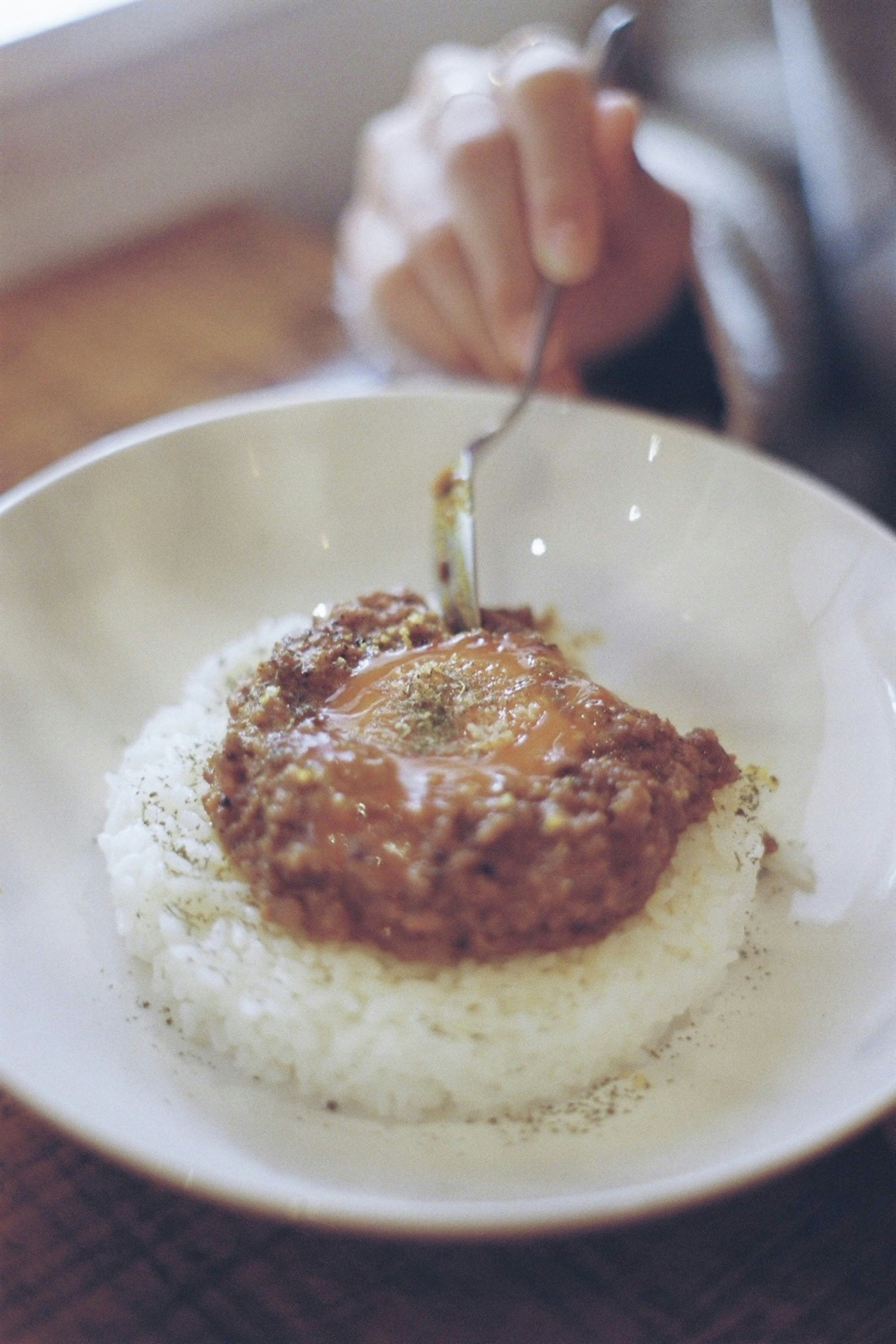 Sepiring nasi dengan patty hamburger dan telur goreng di atasnya