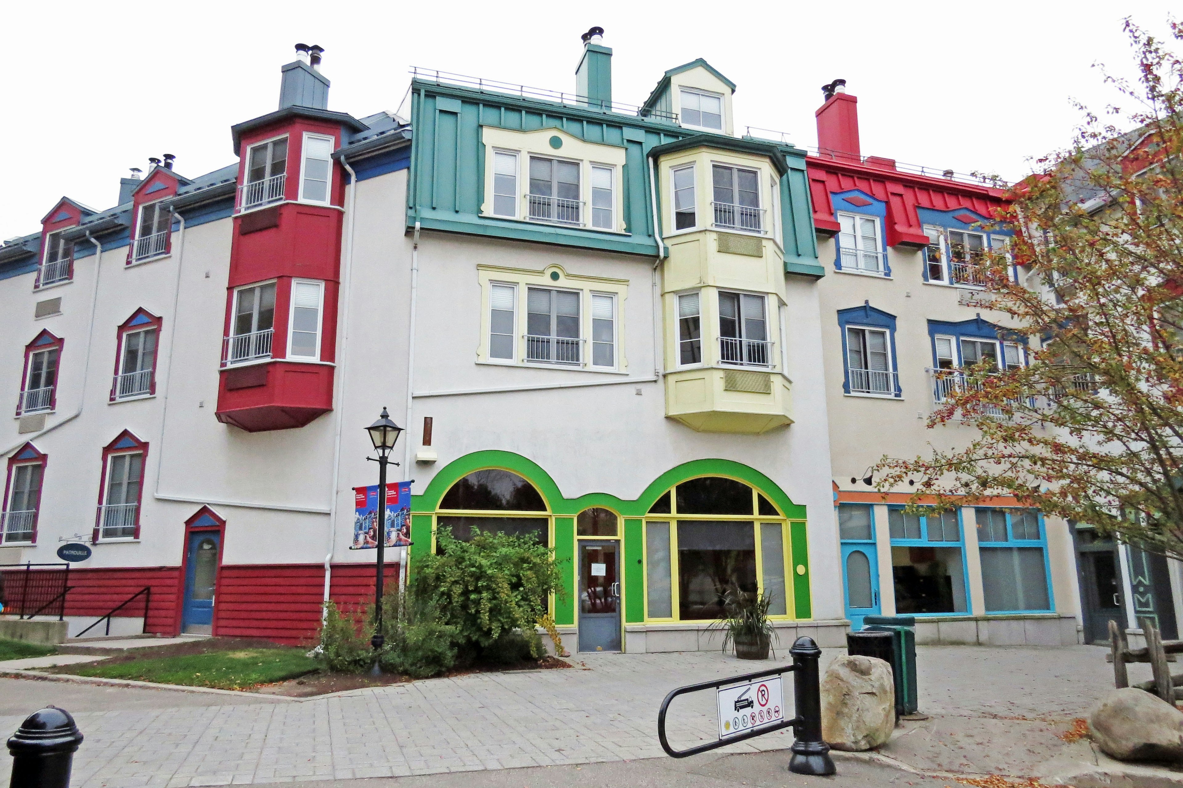 Fachada colorida de un edificio con balcones y ventanas rojas, verdes y azules