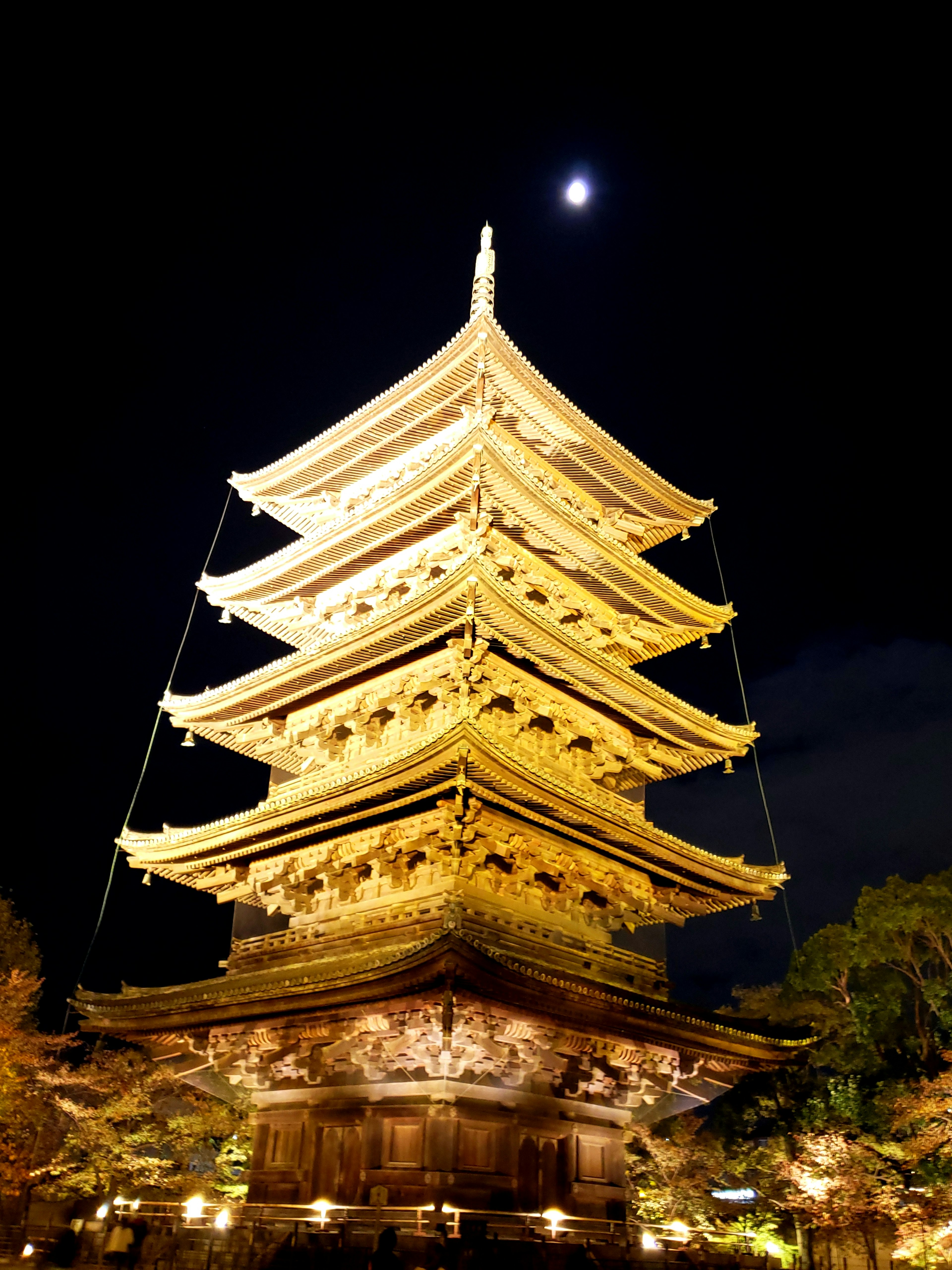 Beautiful five-story pagoda illuminated at night with a crescent moon