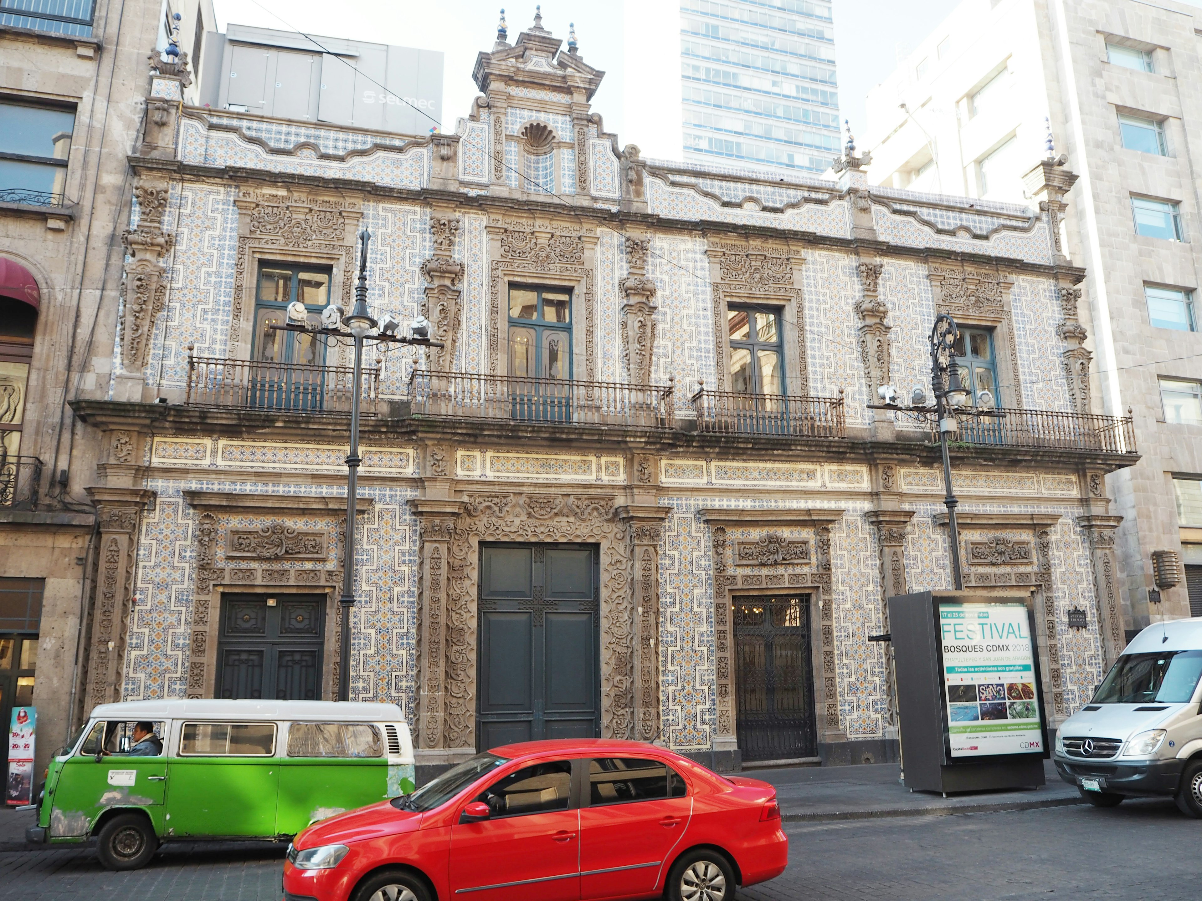 Historisches Gebäude mit verzierter Fassade und rotem Auto auf der Straße