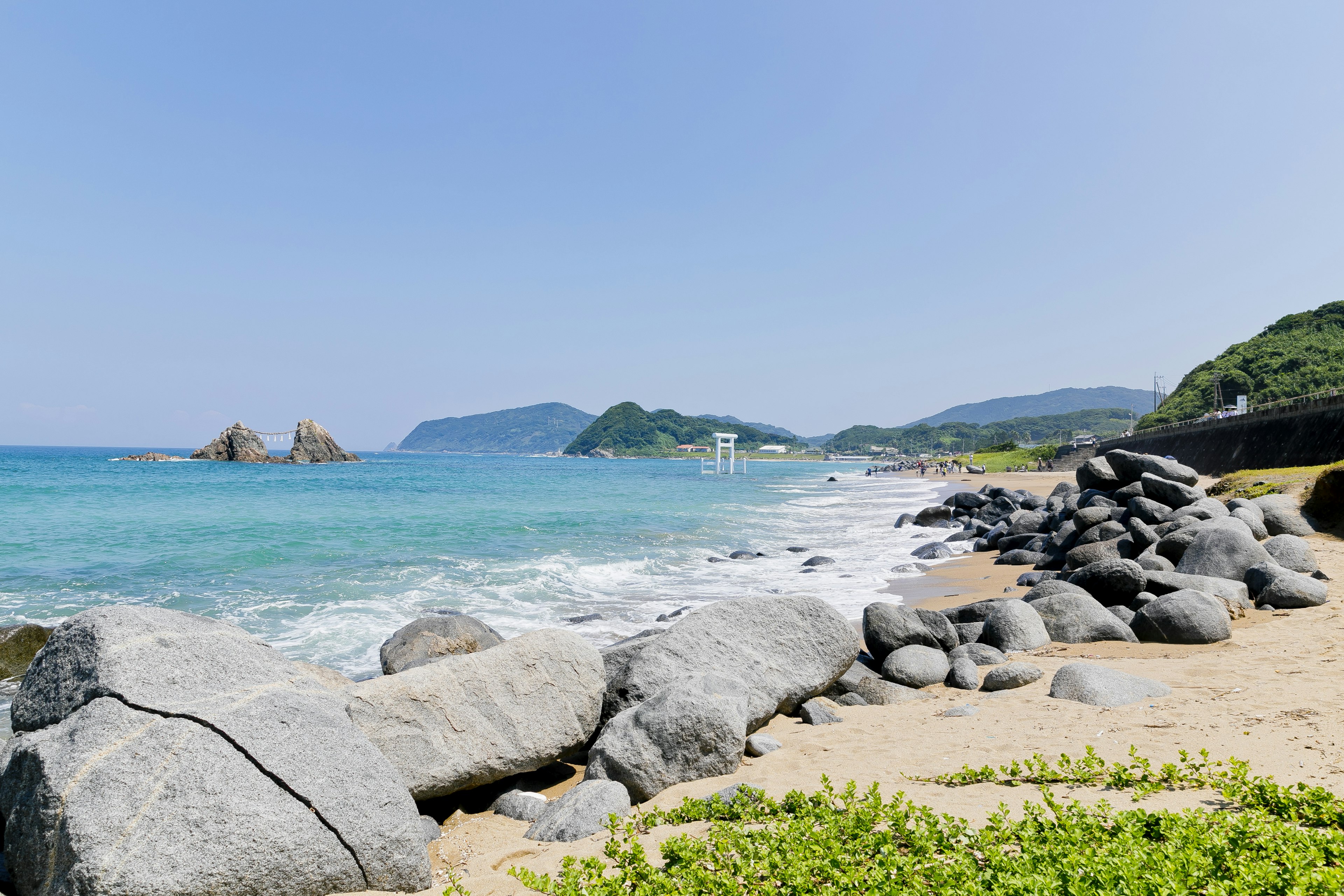 Pemandangan pantai yang indah dengan laut biru dan batu