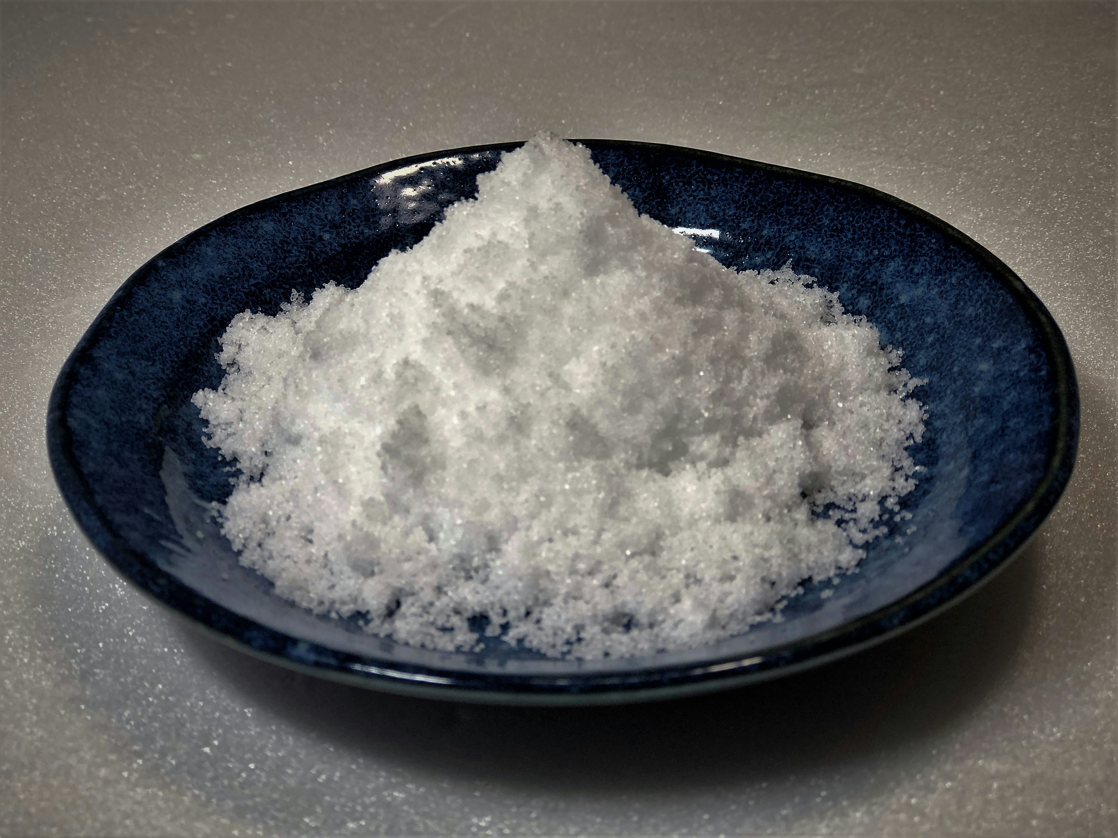 A mound of white salt on a blue plate