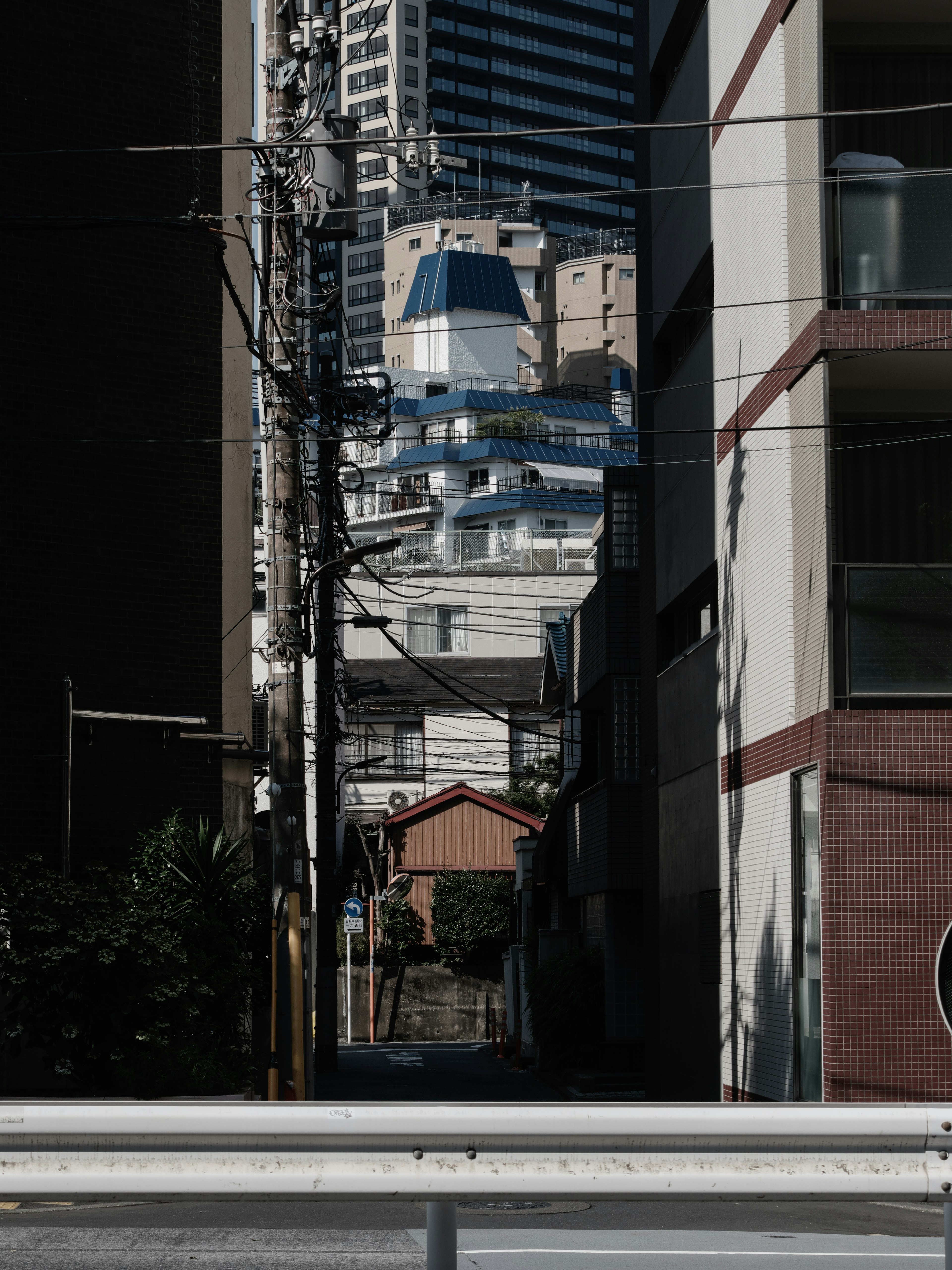 Vista de edificios con rascacielos y un callejón estrecho al fondo