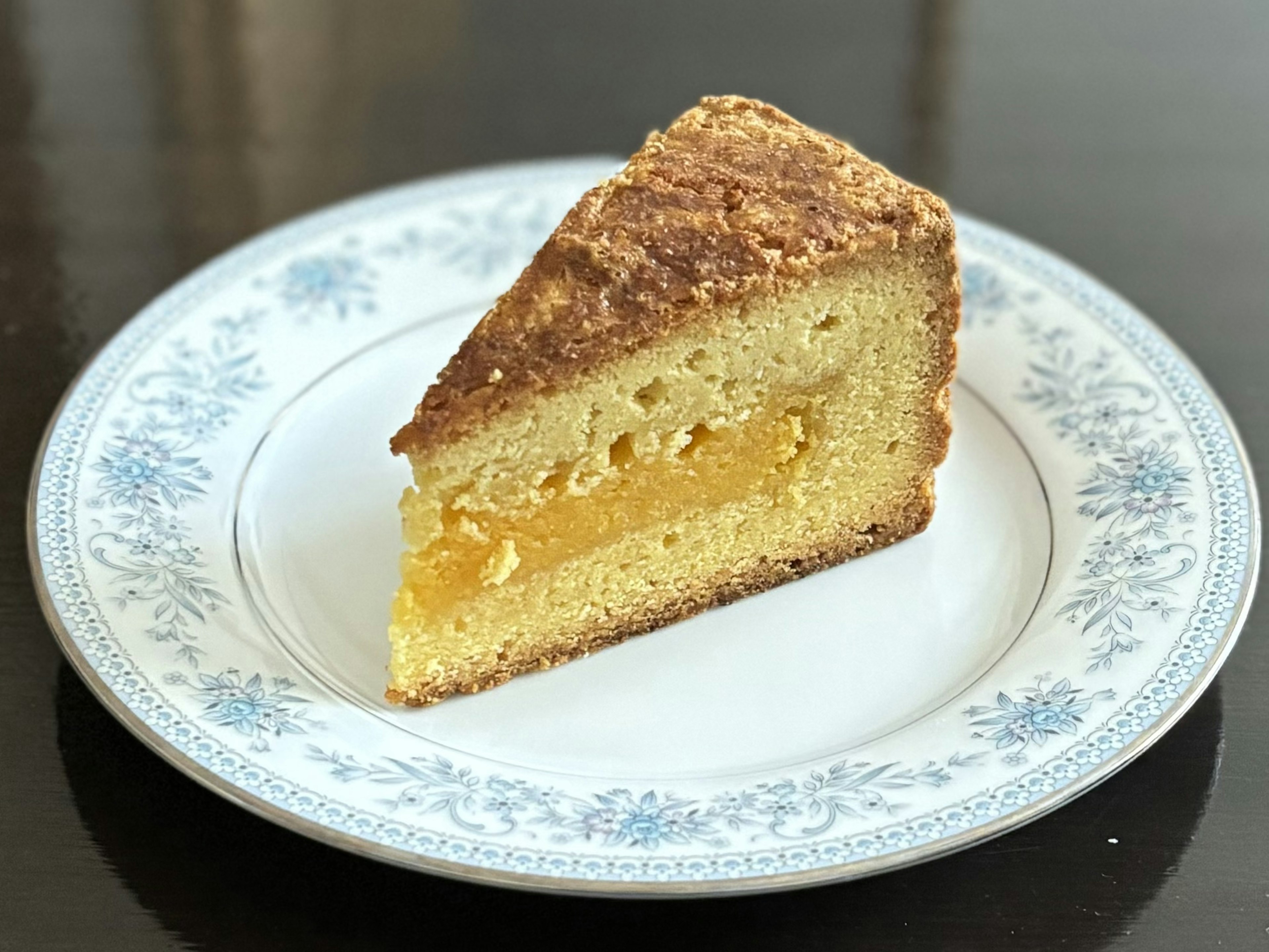 Una rebanada de pastel deliciosa en un plato con diseño floral azul