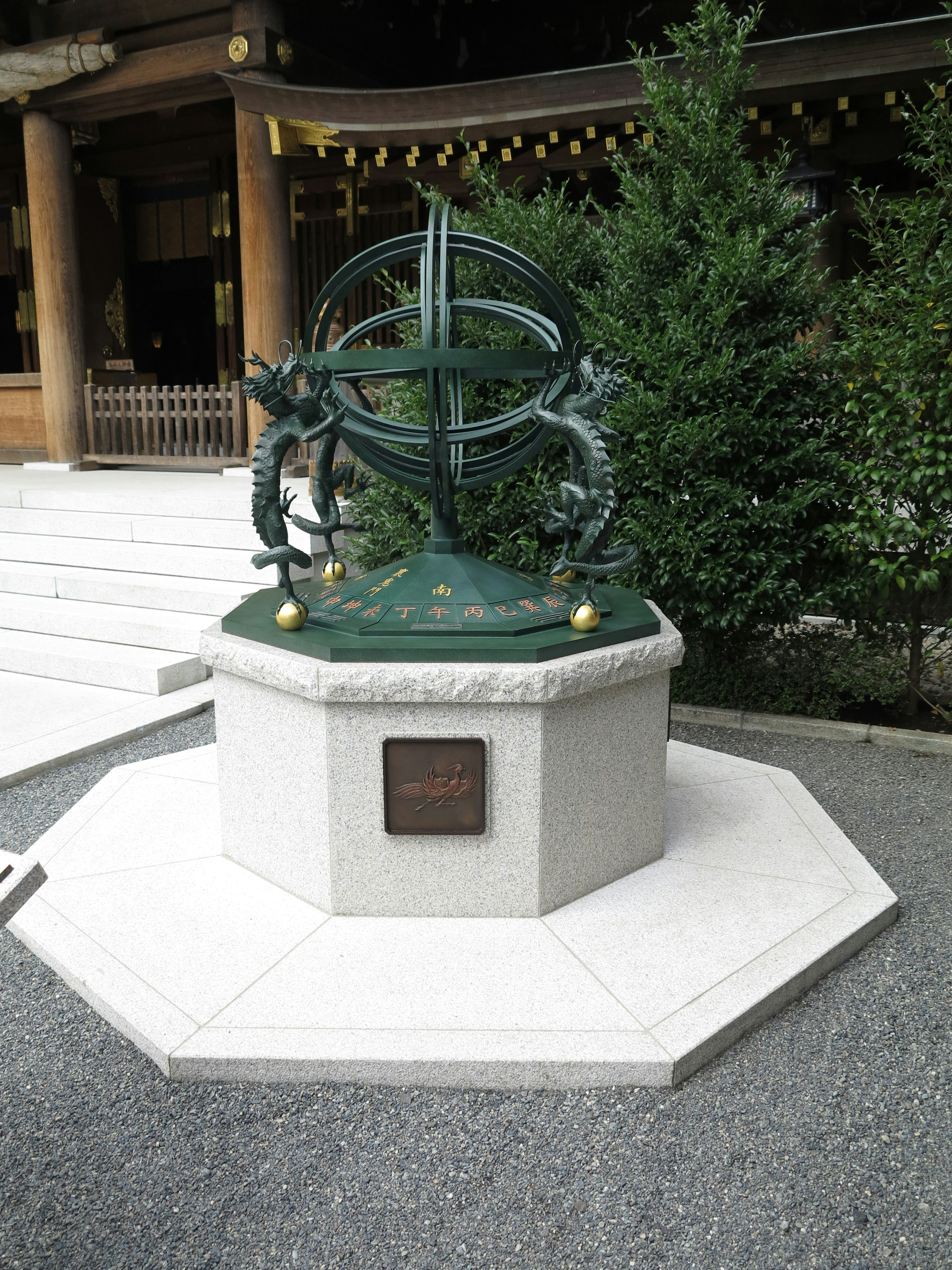 Intricate design of an armillary sphere sculpture near a shrine