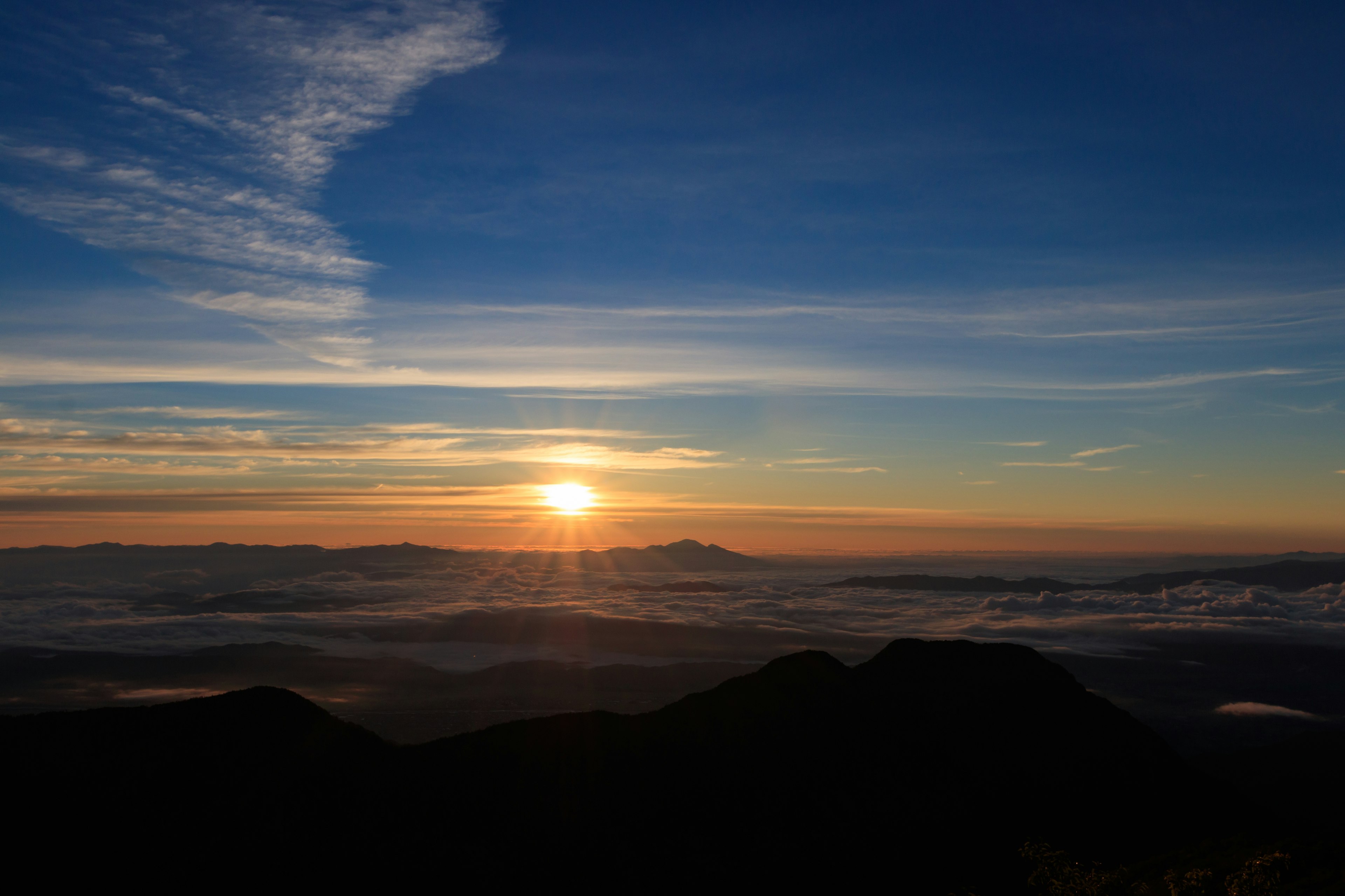 Pemandangan matahari terbit yang menakjubkan di atas gunung dengan awan di latar depan