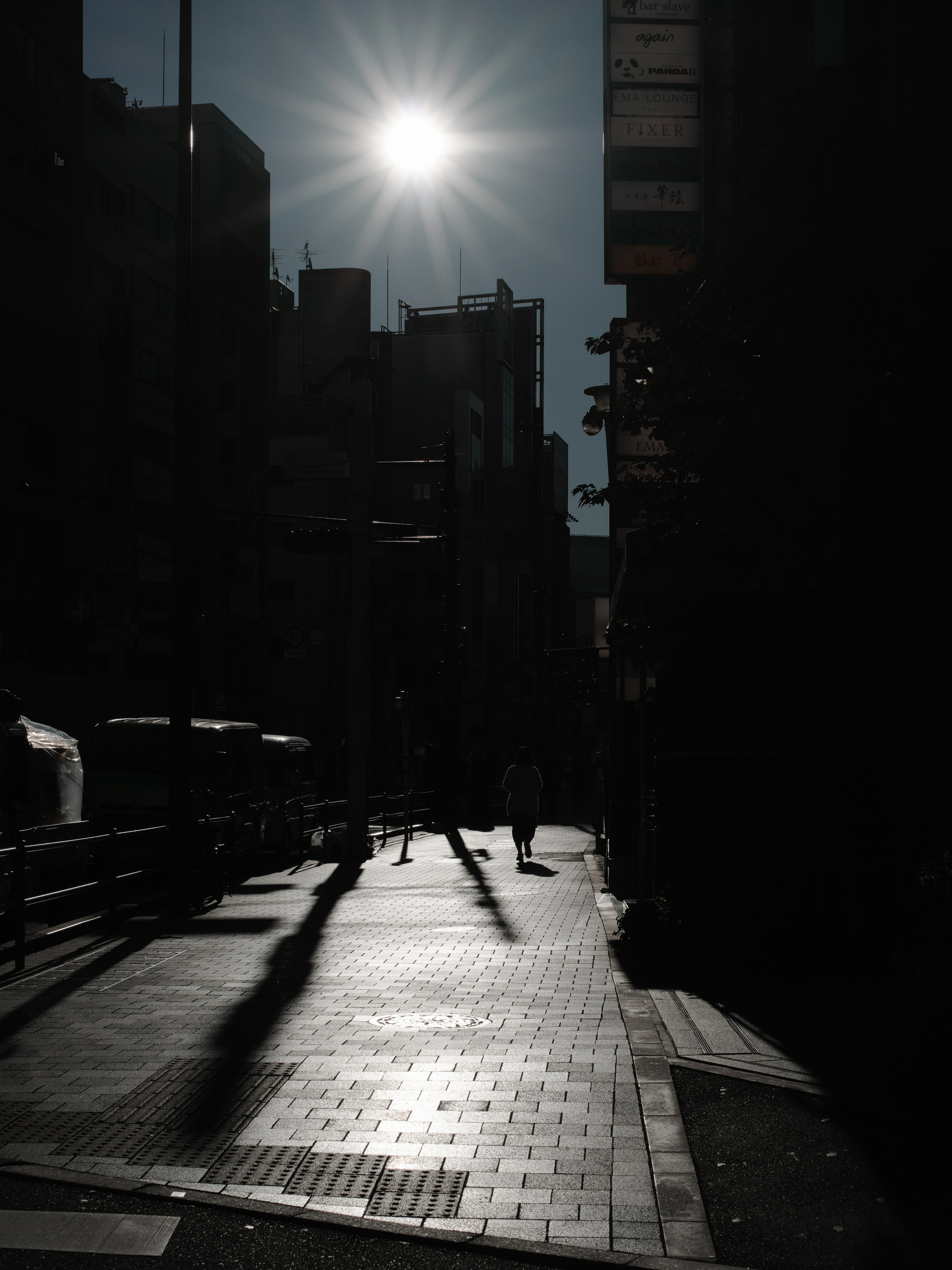 暗い街路に差し込む太陽光と影