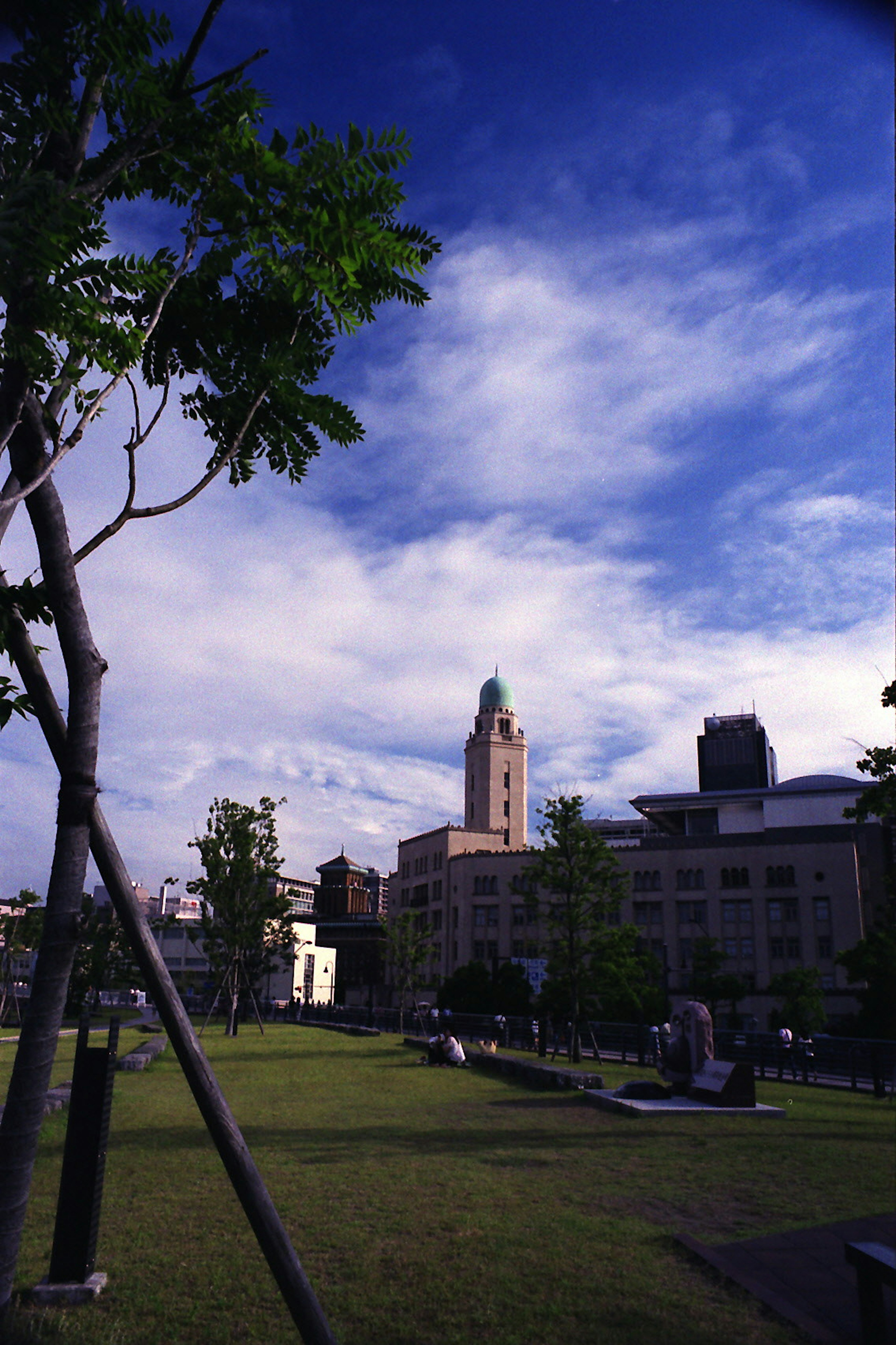 Parkszene mit historischem Gebäude unter blauem Himmel