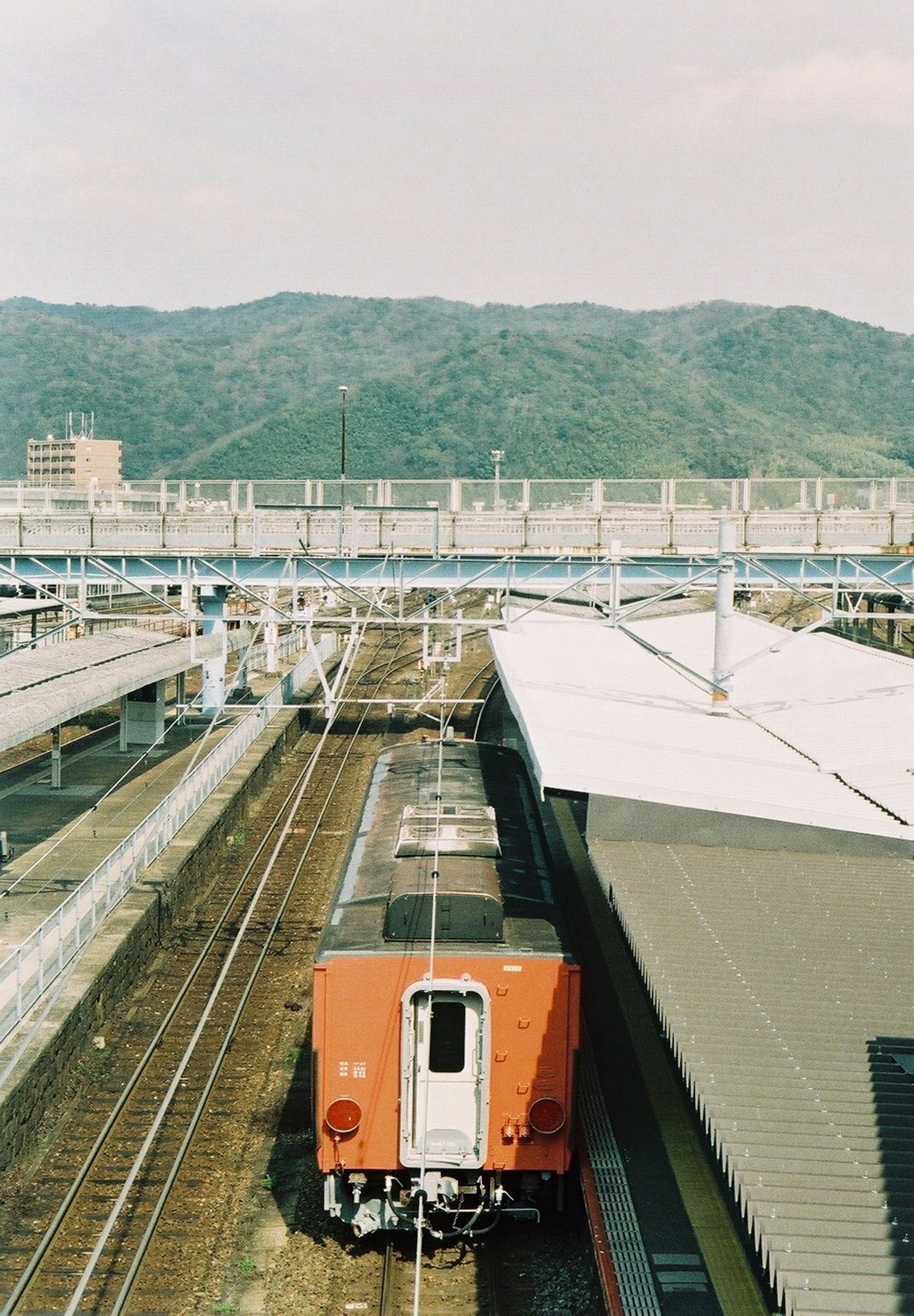 Pemandangan stasiun kereta dengan latar belakang gunung