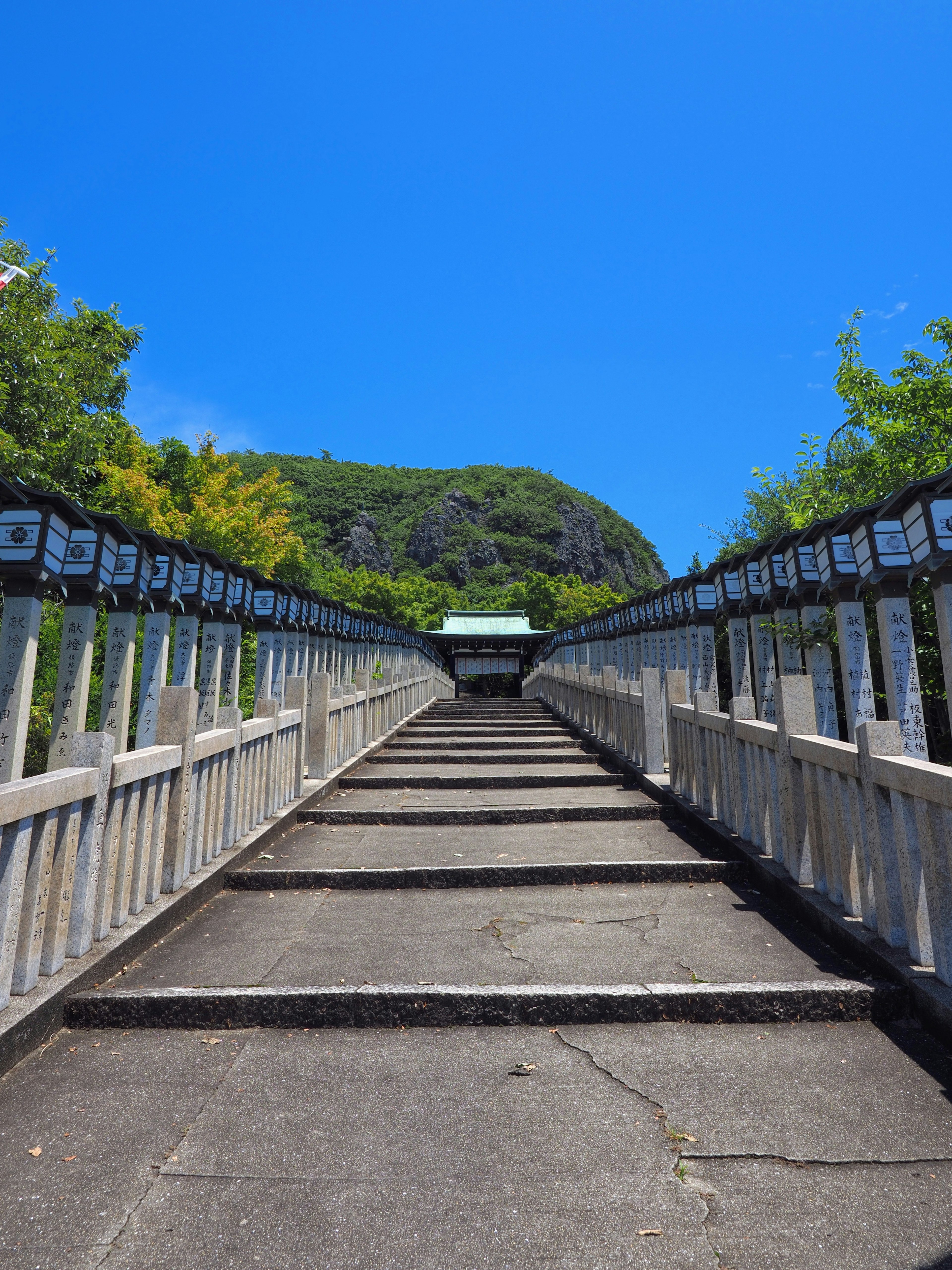 Un pont en escaliers menant vers le haut sous un ciel bleu clair avec de la verdure environnante