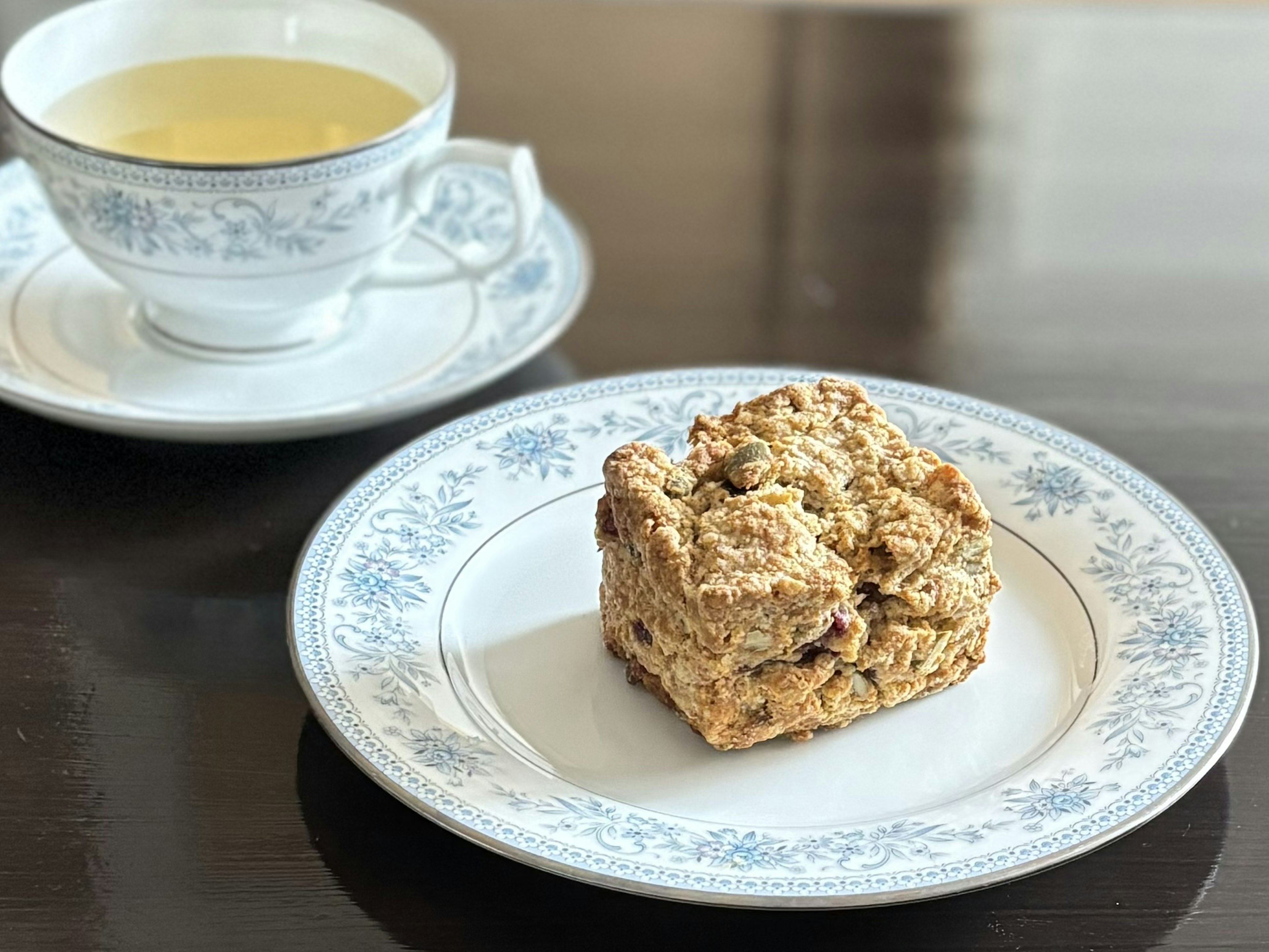 青い花模様の皿に乗った焼き菓子とティーカップ