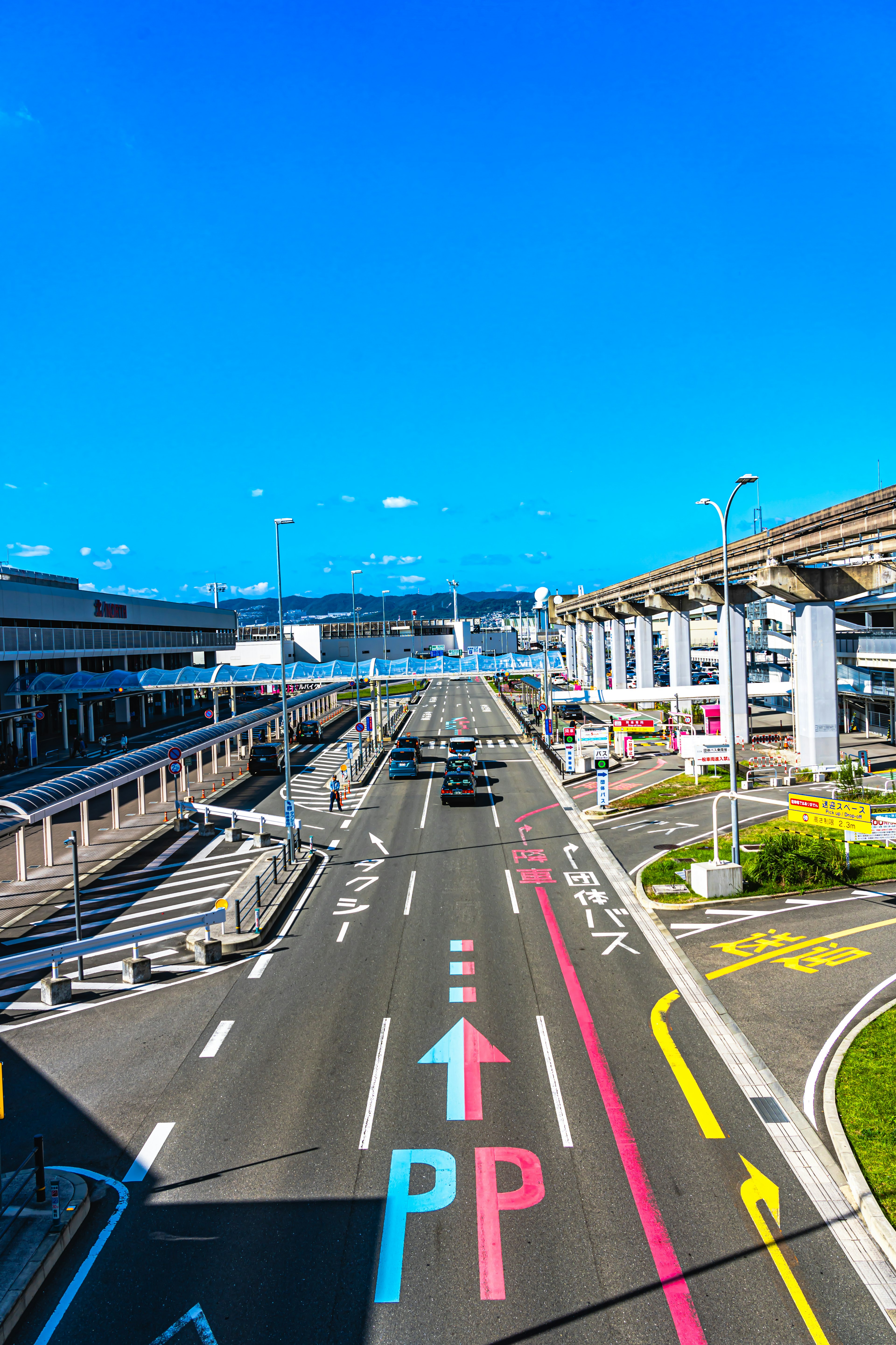 View of an airport road with blue sky traffic signs and color-coded lanes