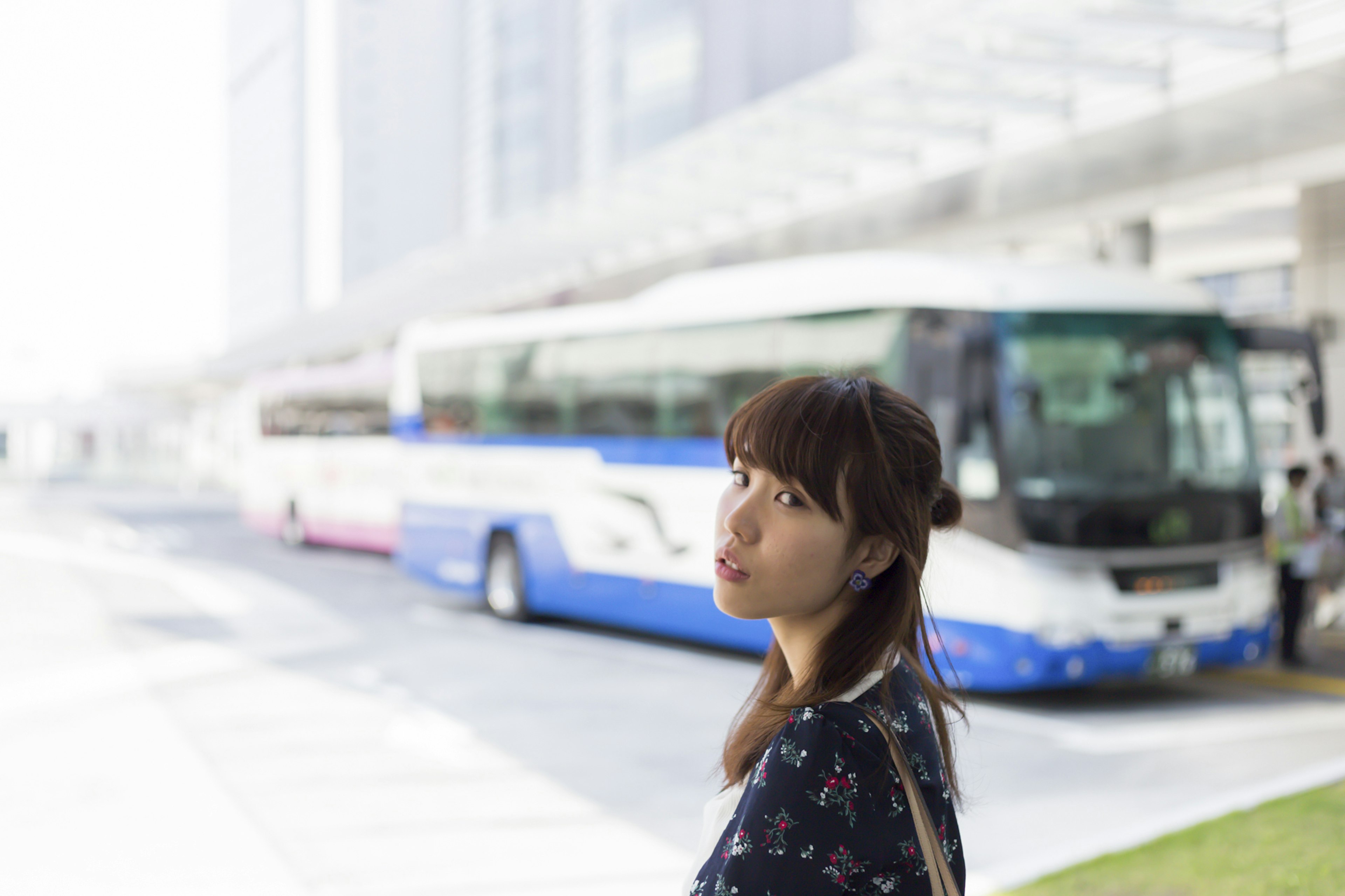 A woman looking back near a bus station