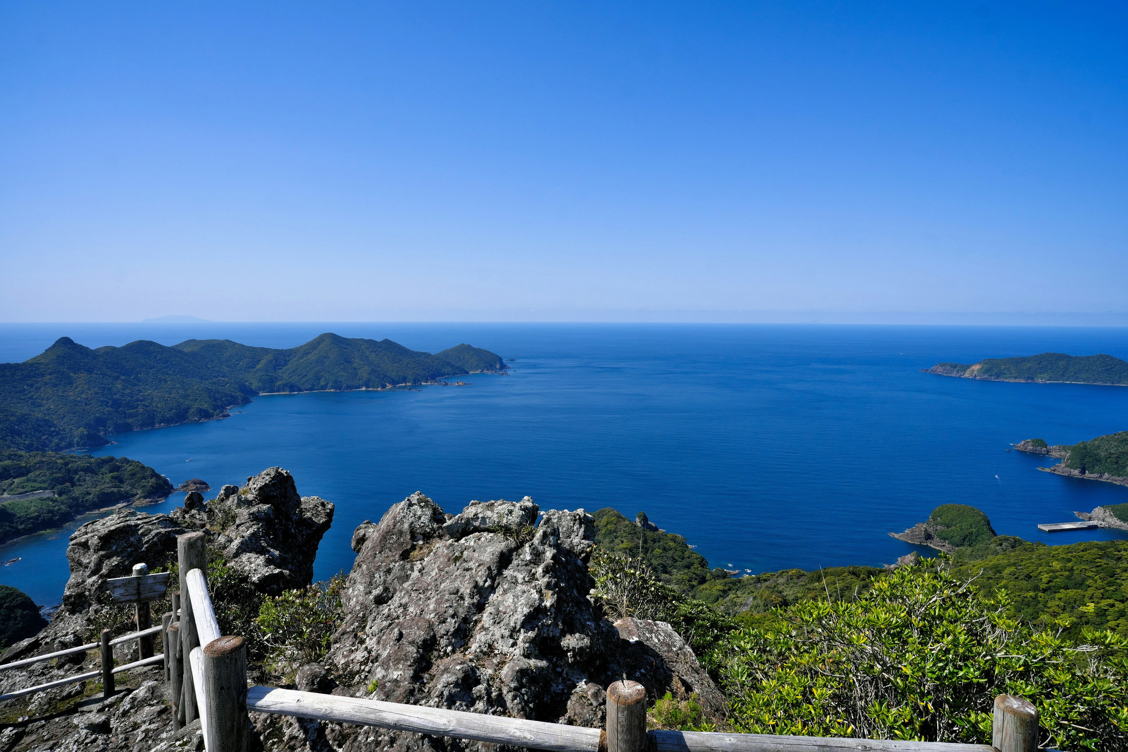 Pemandangan panorama laut biru dan pegunungan hijau