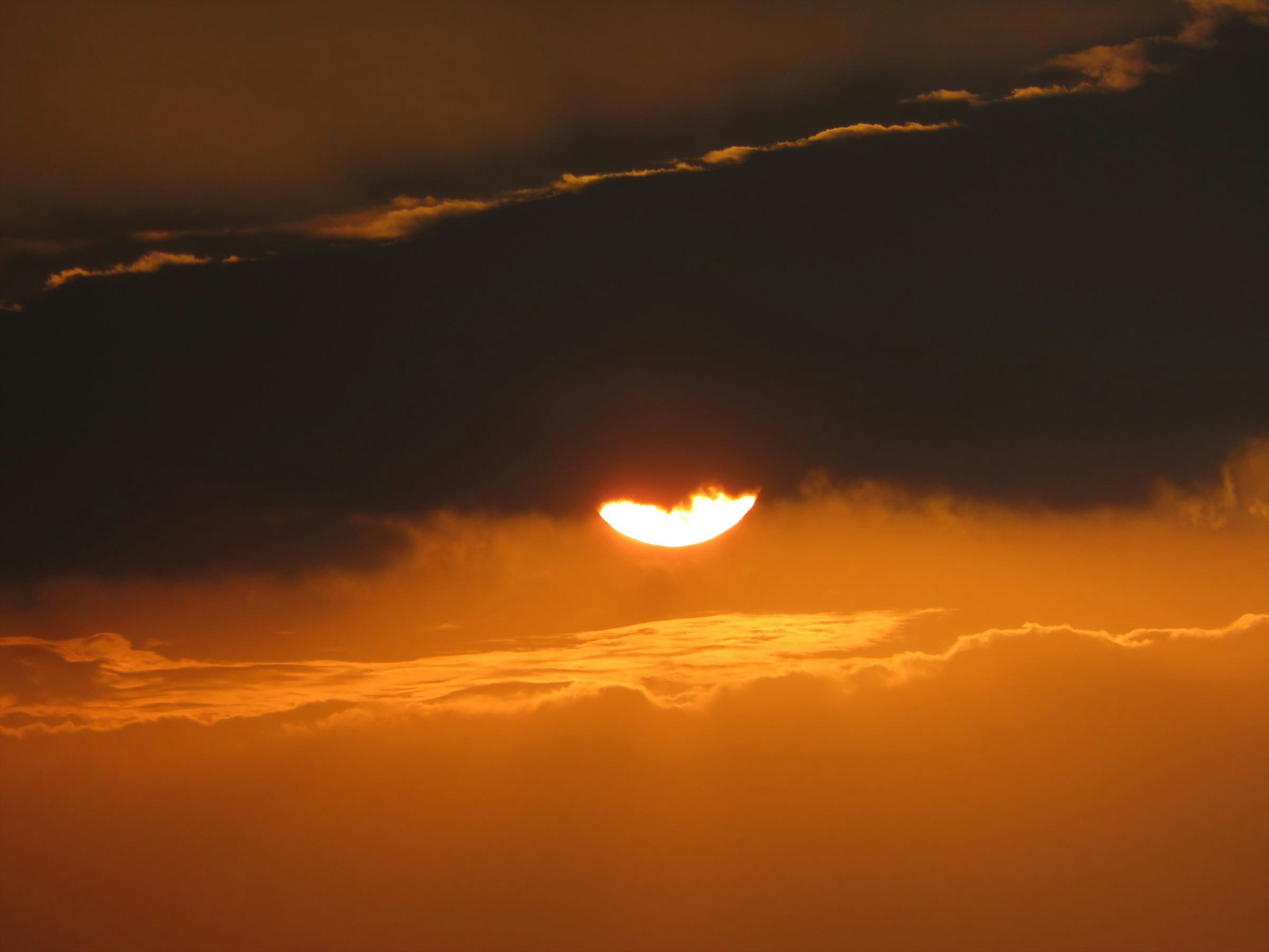 Sonnenlicht, das durch dunkle Wolken bei Sonnenuntergang scheint