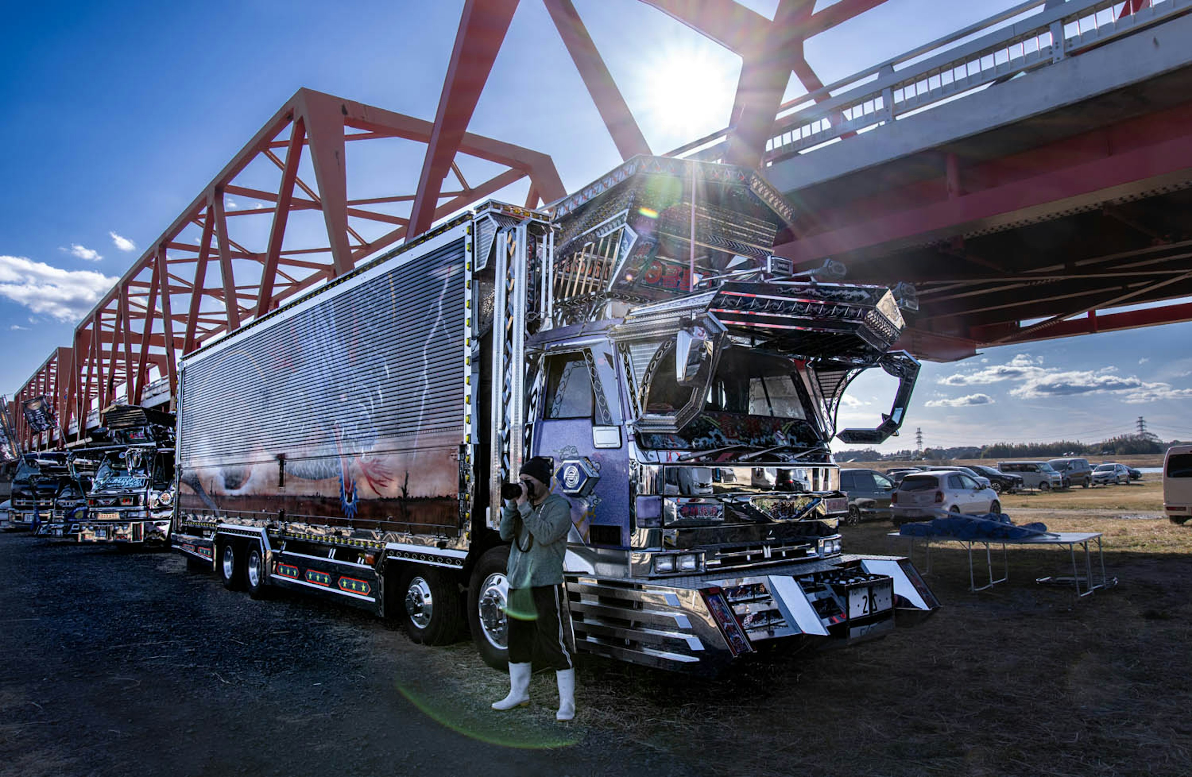 Camion garé sous un pont rouge avec un conducteur