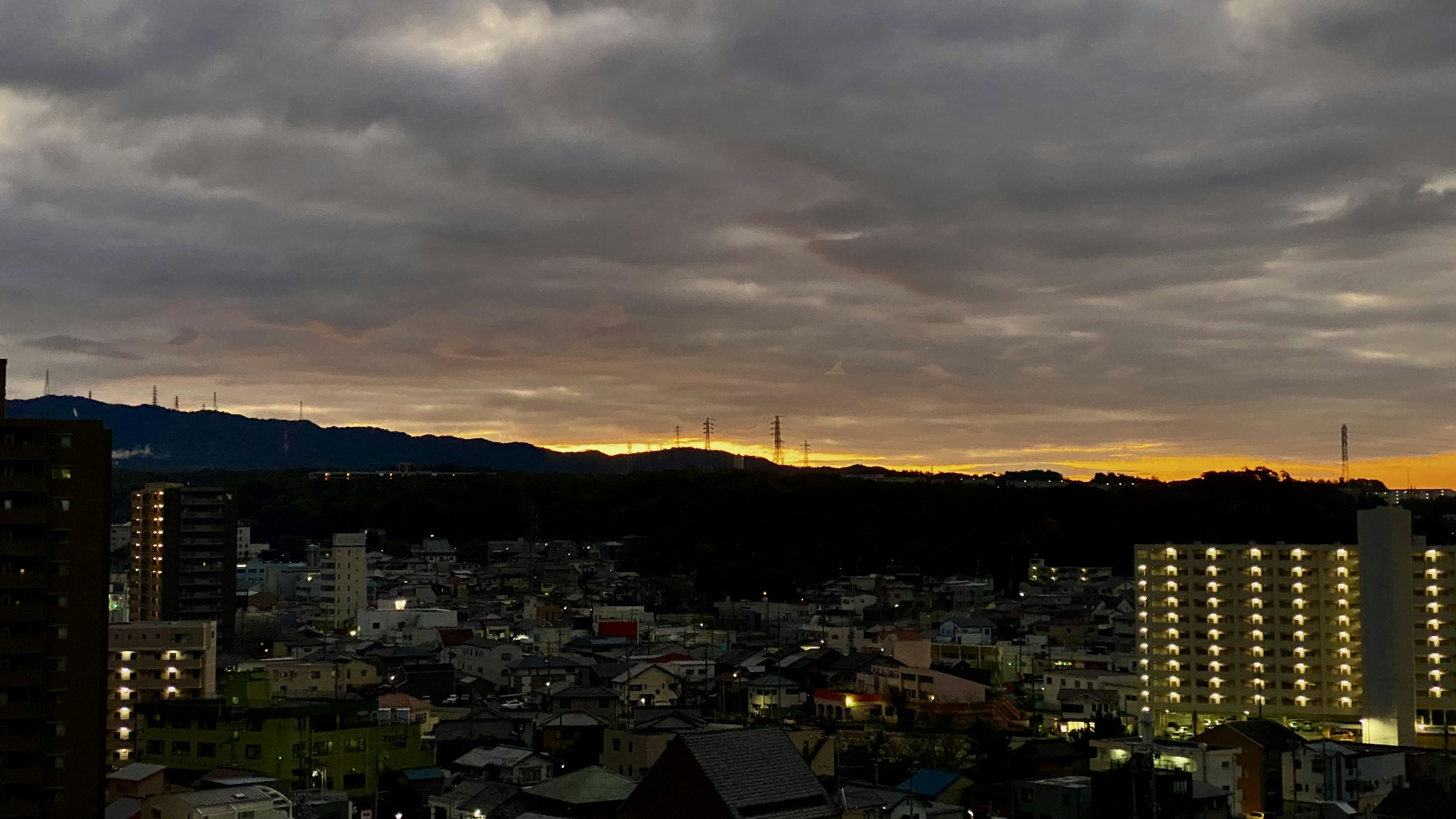 黄昏时分的城市景观，夕阳天空，高楼和住宅可见