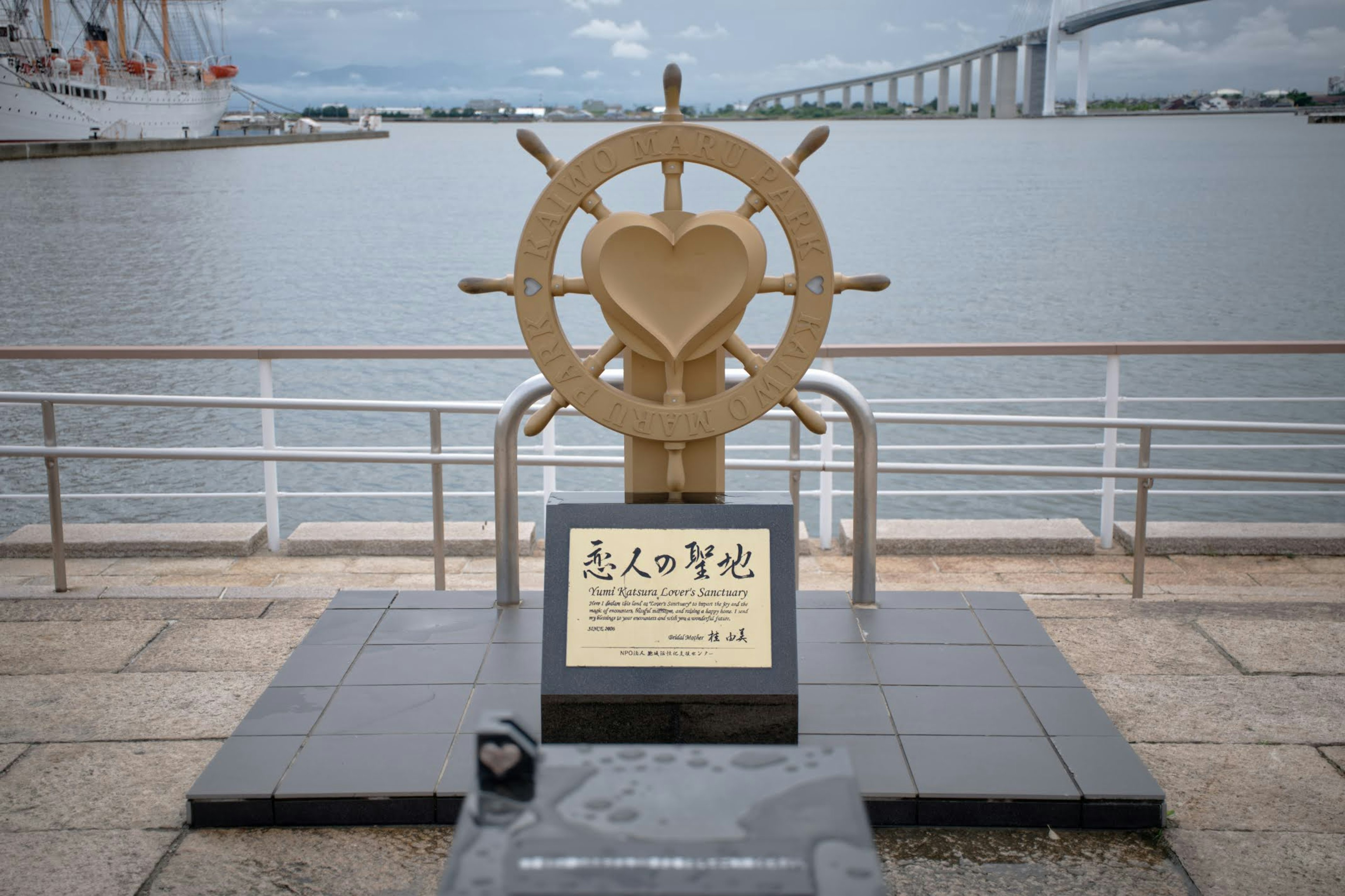 Monument avec une roue de bateau en forme de cœur près de la mer