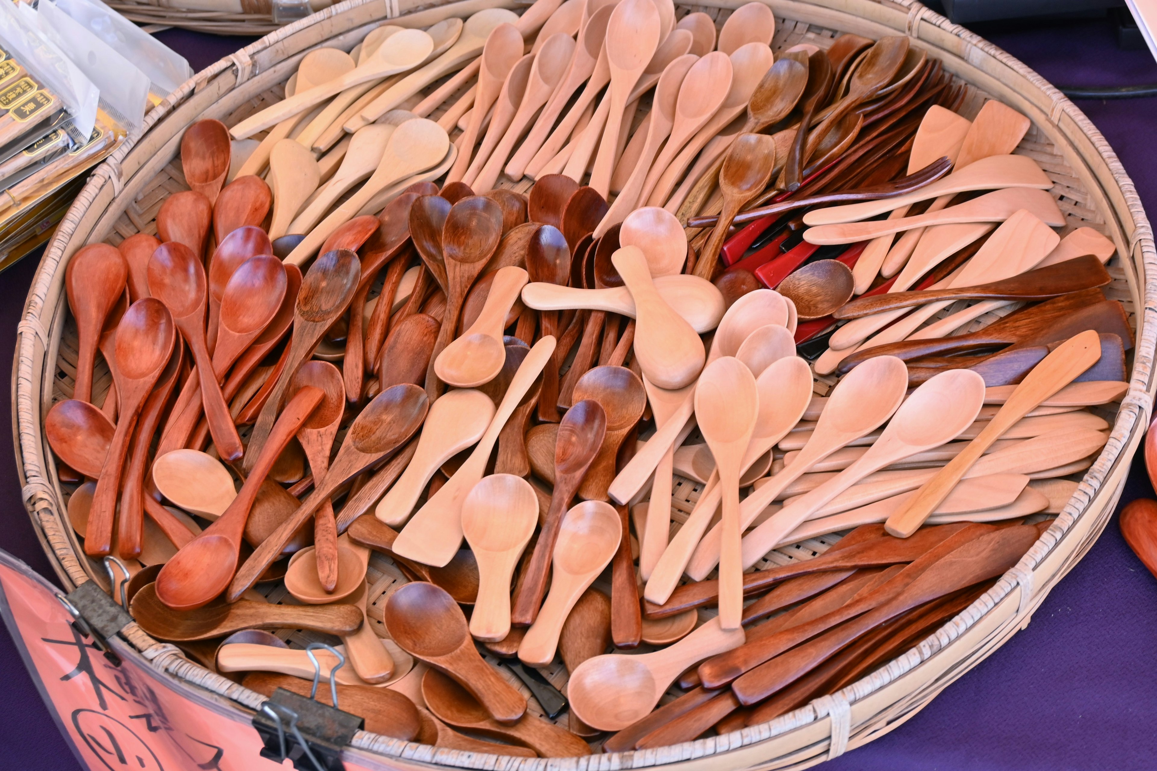 A basket filled with various wooden spoons