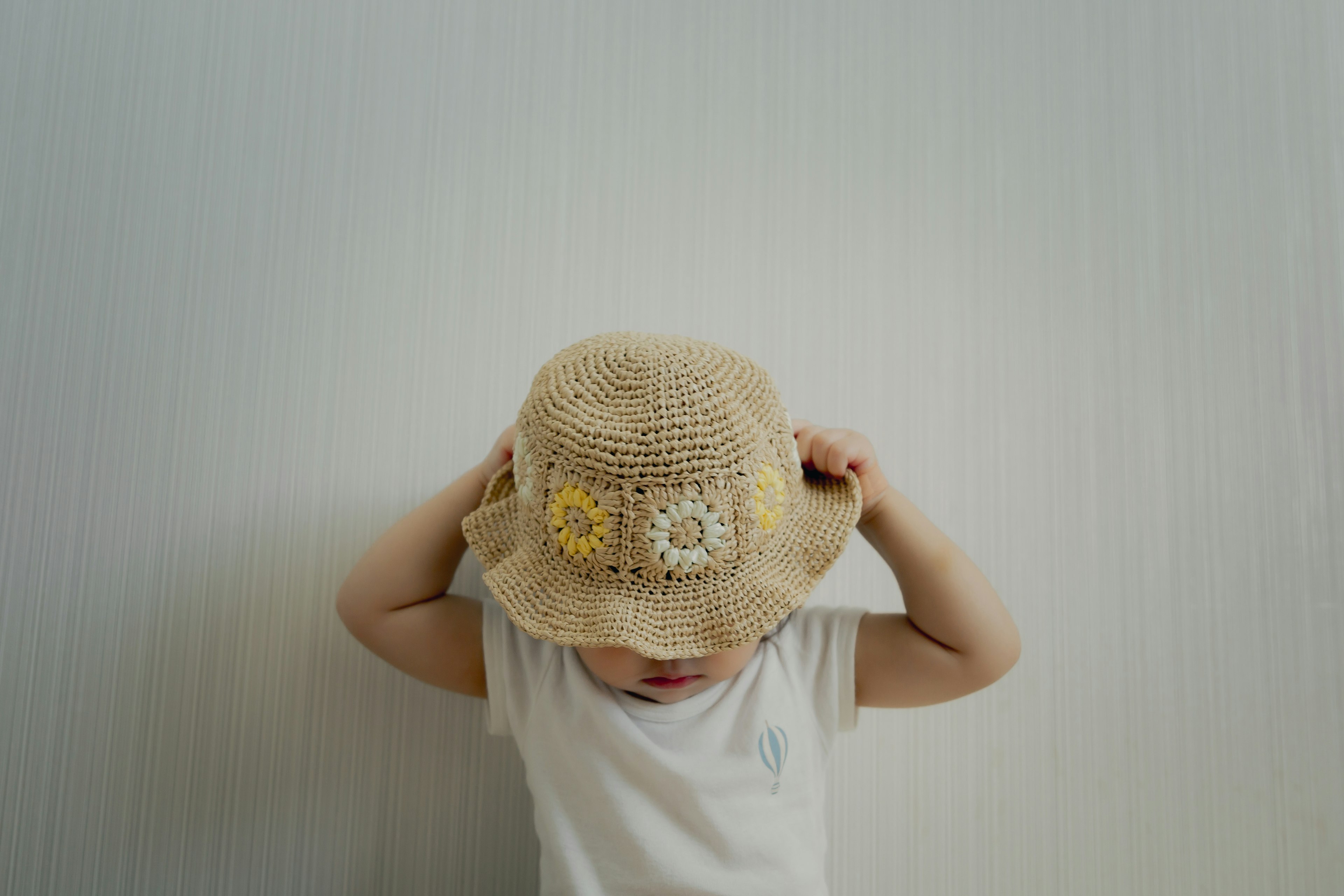 Bambino che indossa un cappello di paglia con ricami floreali