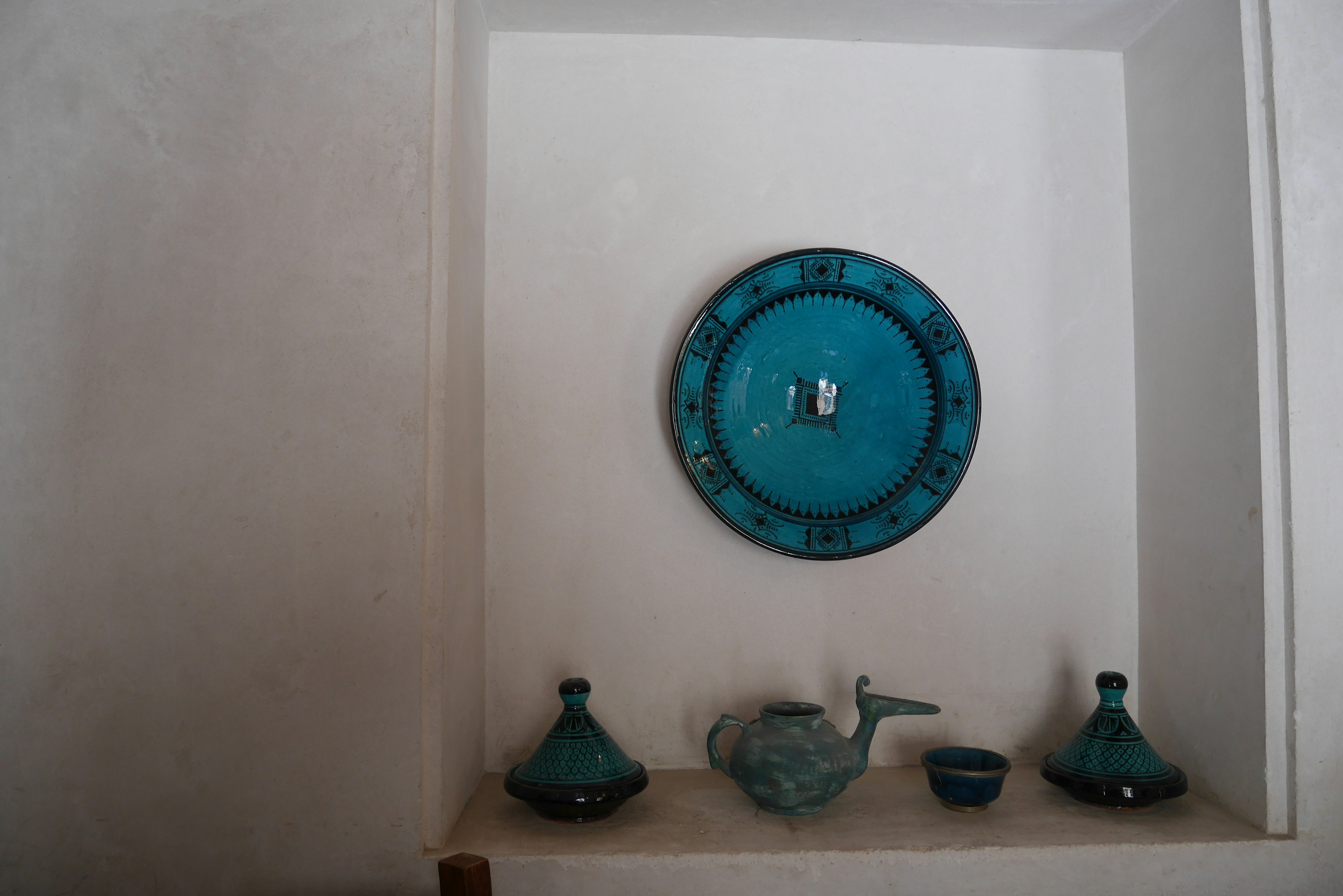 Decorative blue items displayed in a white wall niche