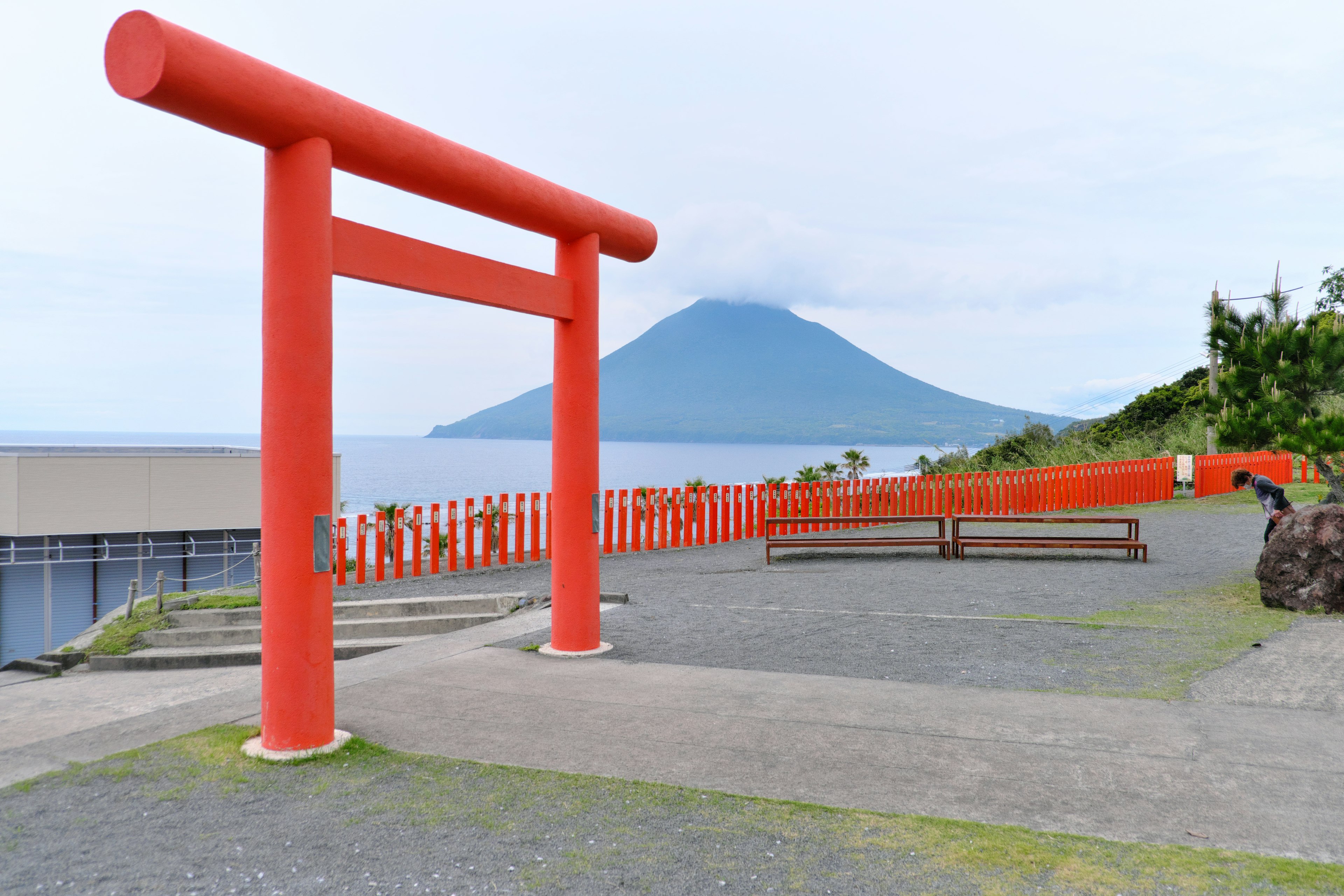 Portique torii rouge avec vue sur la montagne surplombant la mer