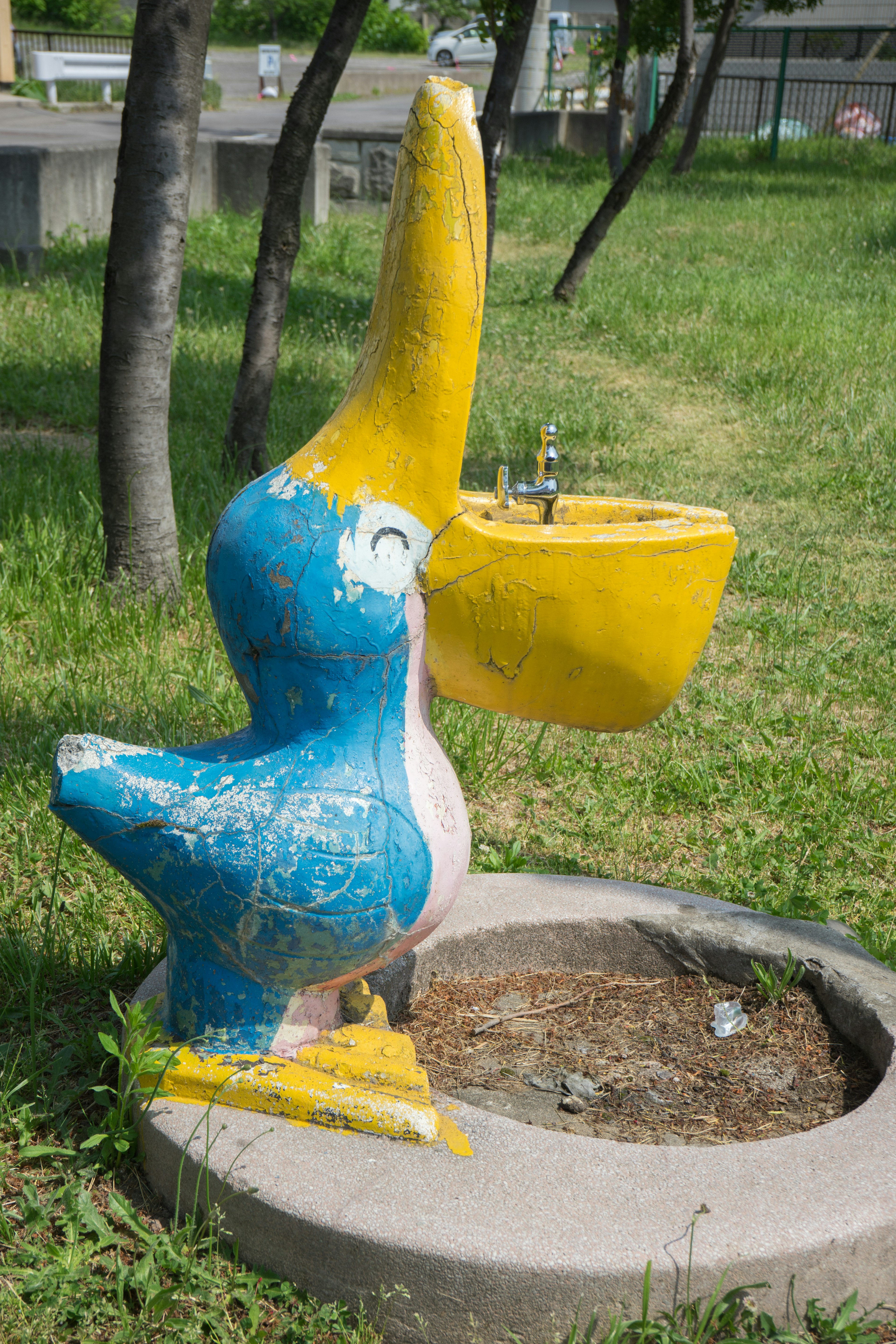 Bunte blaue und gelbe Pelikan-Skulptur als Wasserbrunnen