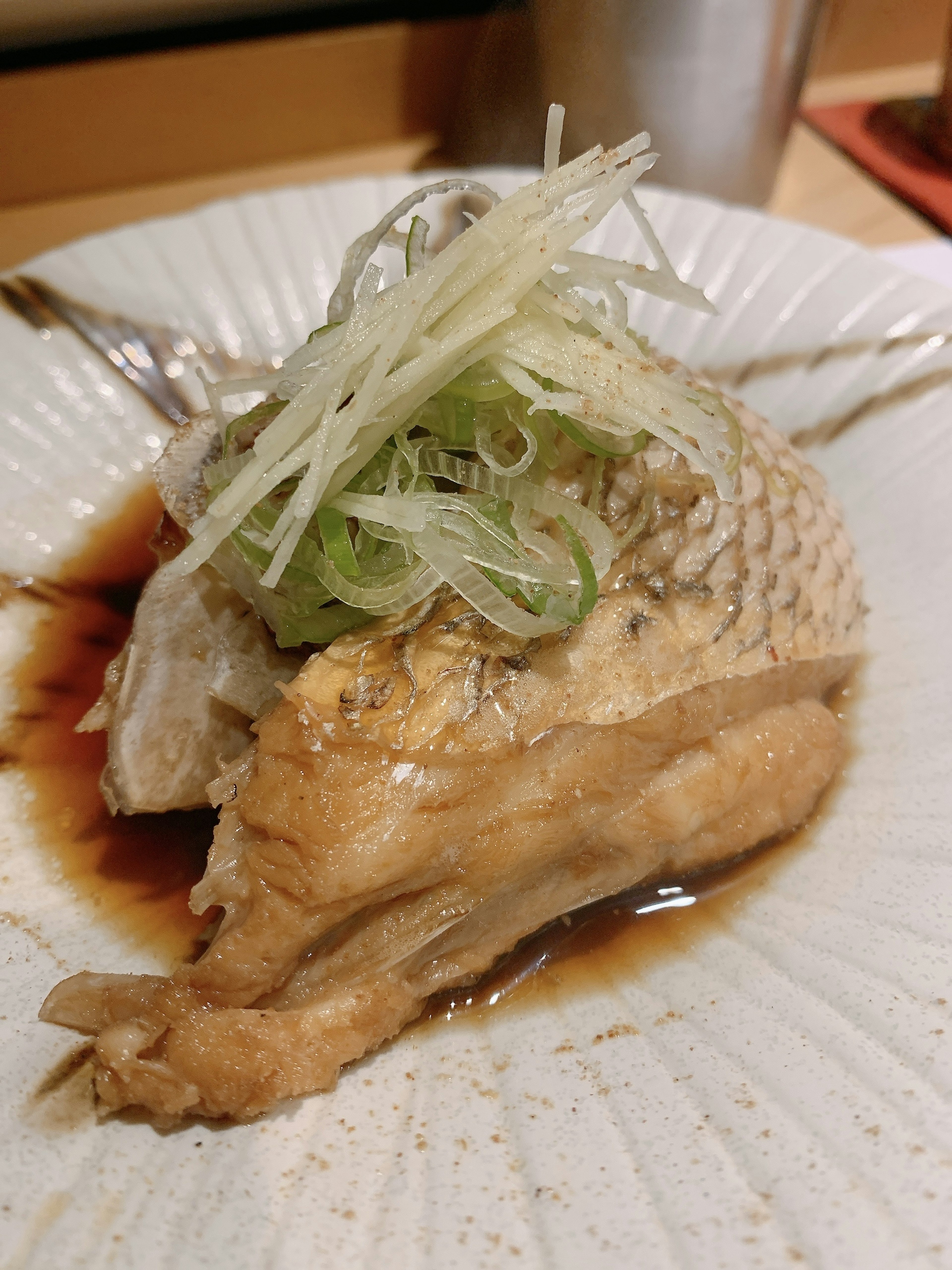 Un plato de pescado decorado con cebollas verdes