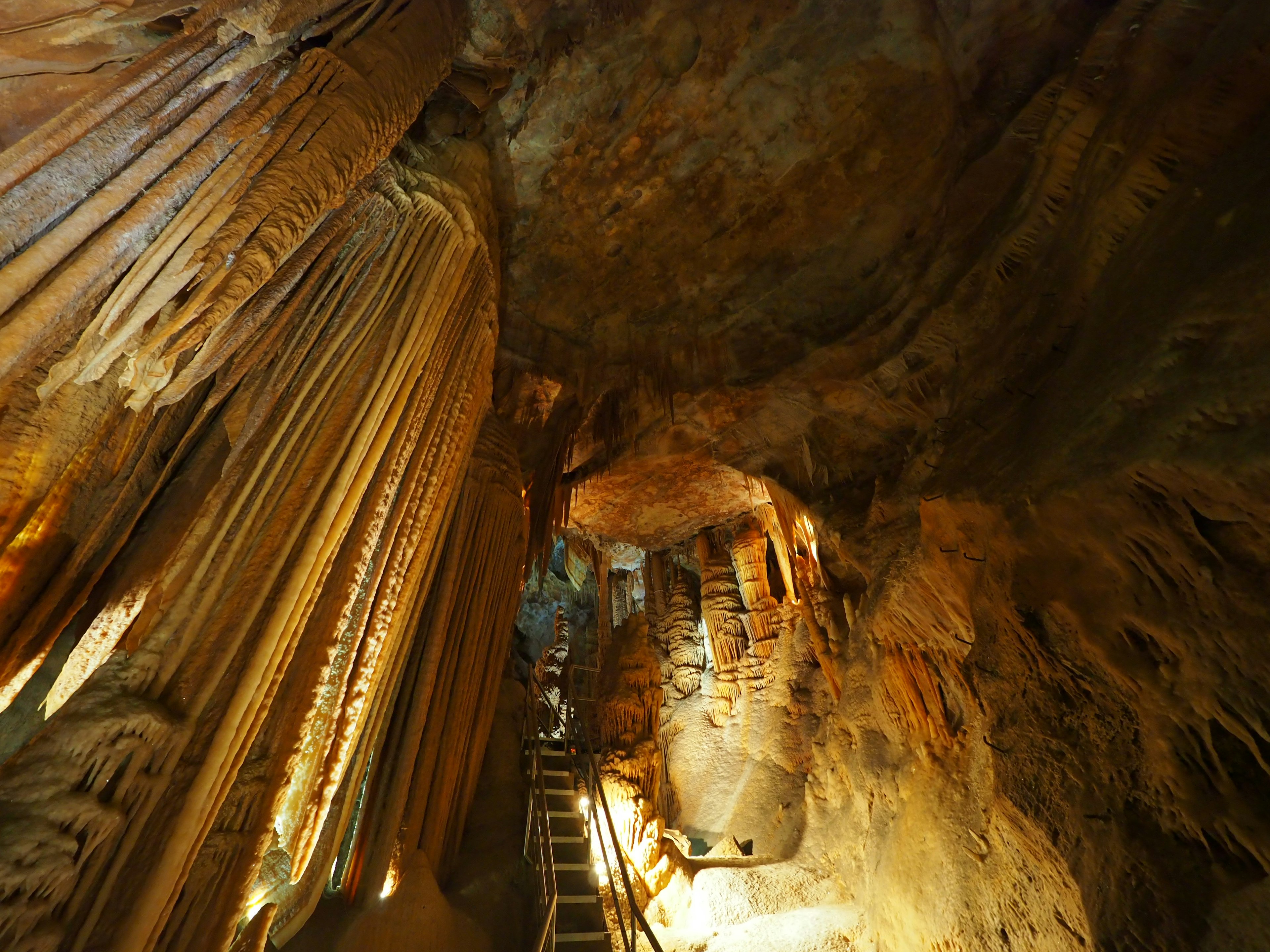 Innere einer Höhle mit Stalaktiten und dramatischer Beleuchtung