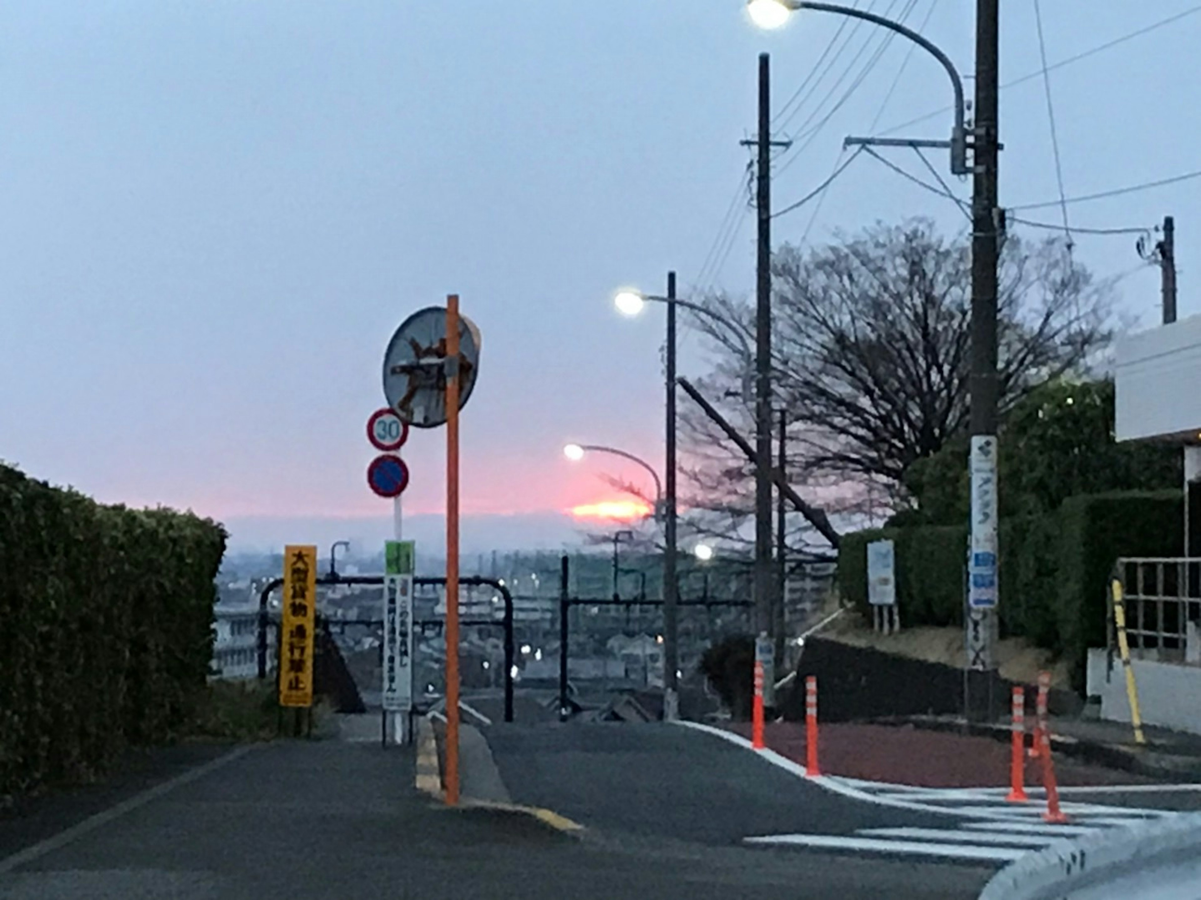 Paysage urbain au coucher du soleil avec des panneaux de signalisation et des lampadaires