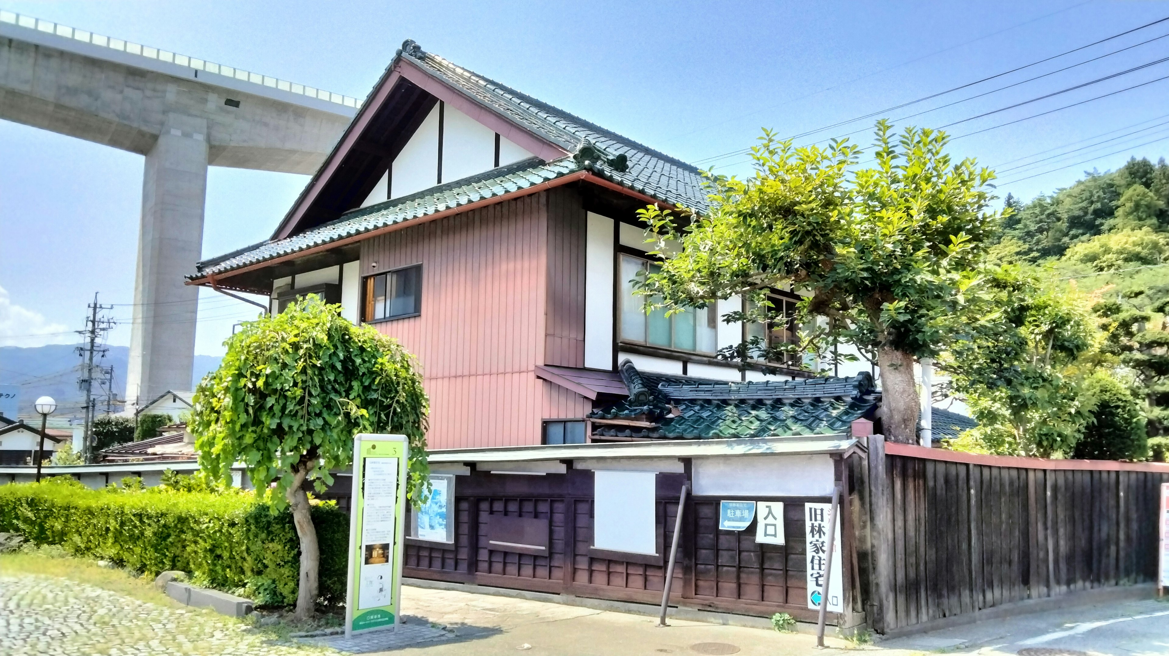 伝統的な日本の家屋が見える風景 高い橋が背景にある