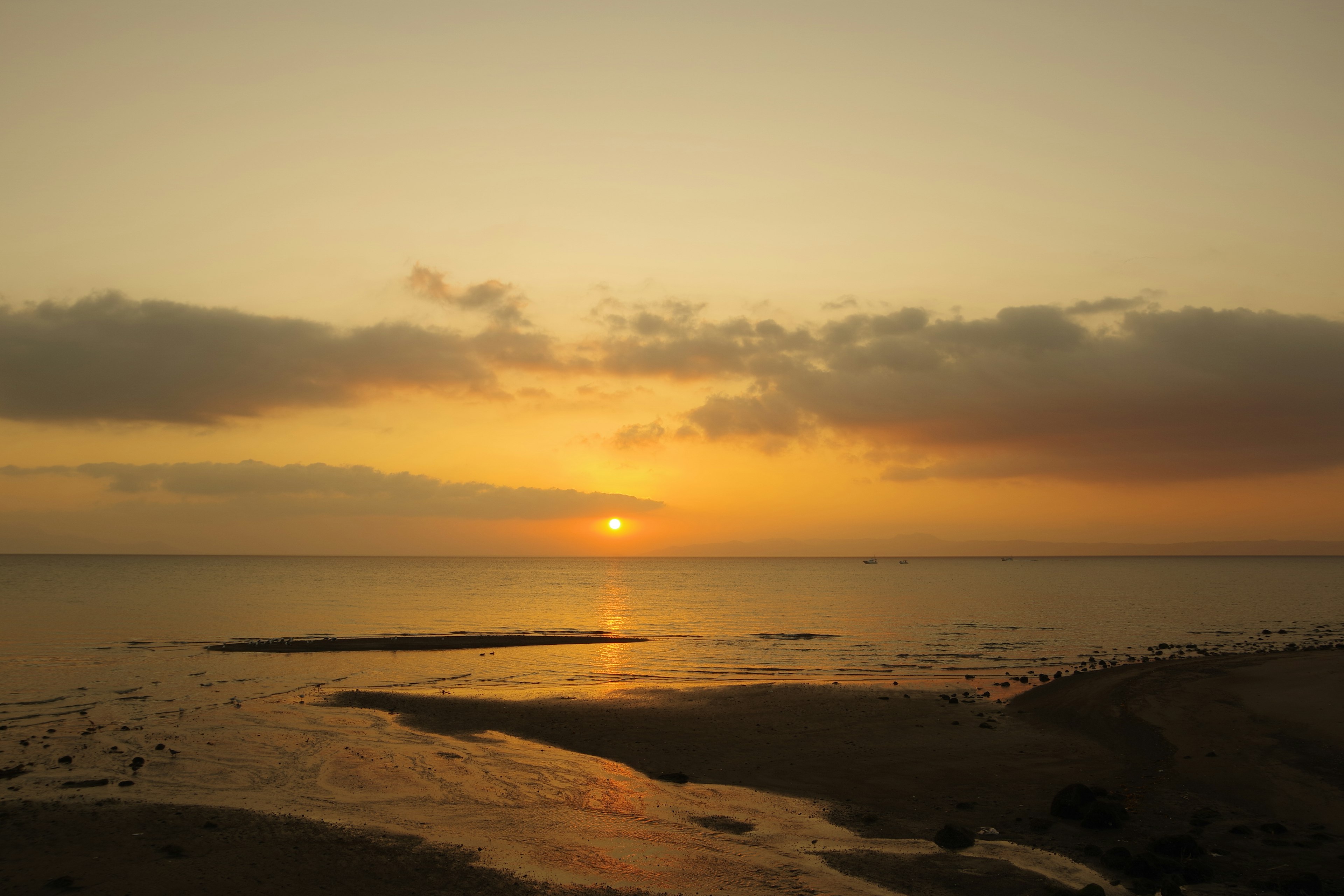 Beautiful sunset over the calm sea with soft clouds