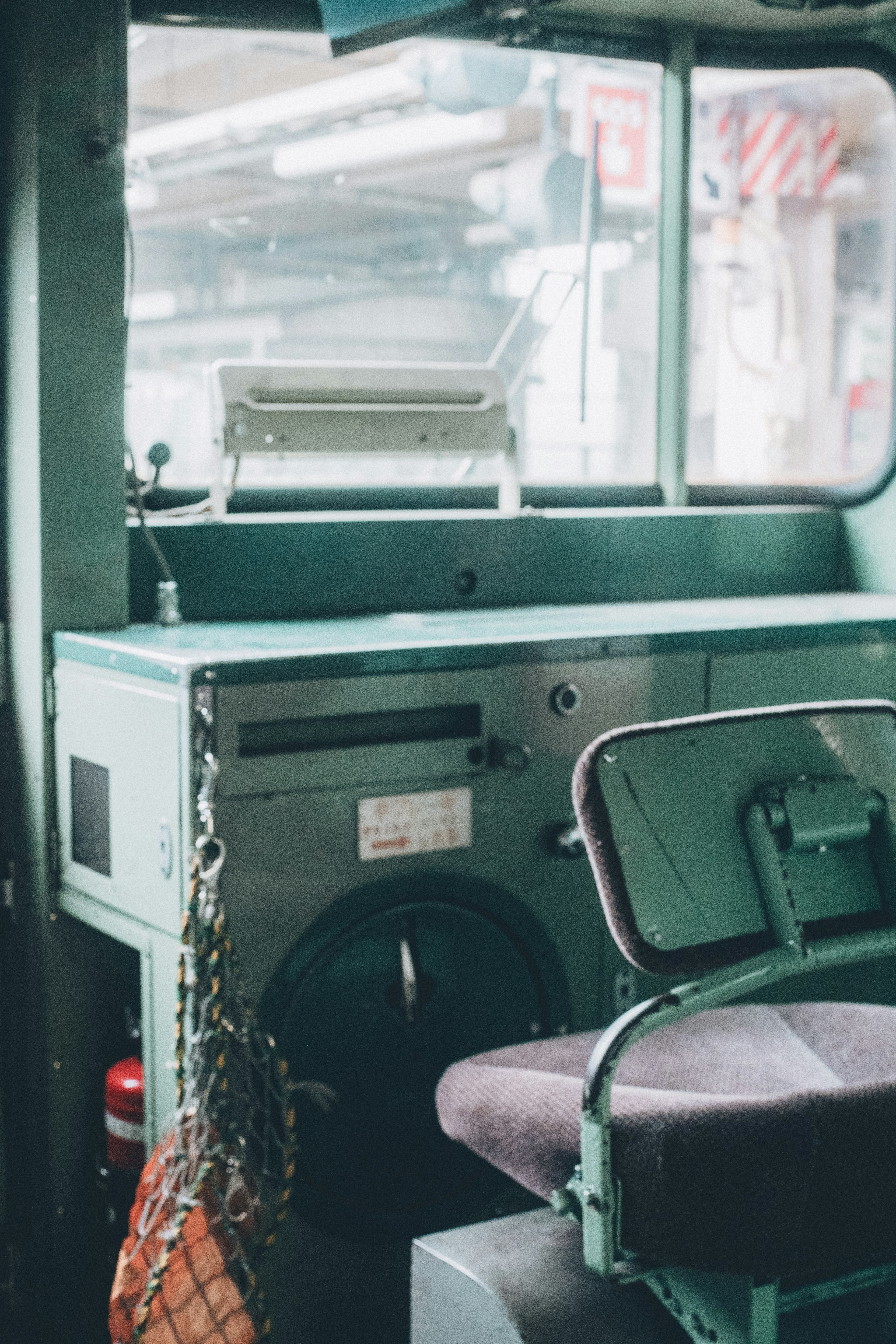 Intérieur du siège conducteur d'un camion vert avec une chaise et un panneau de contrôle