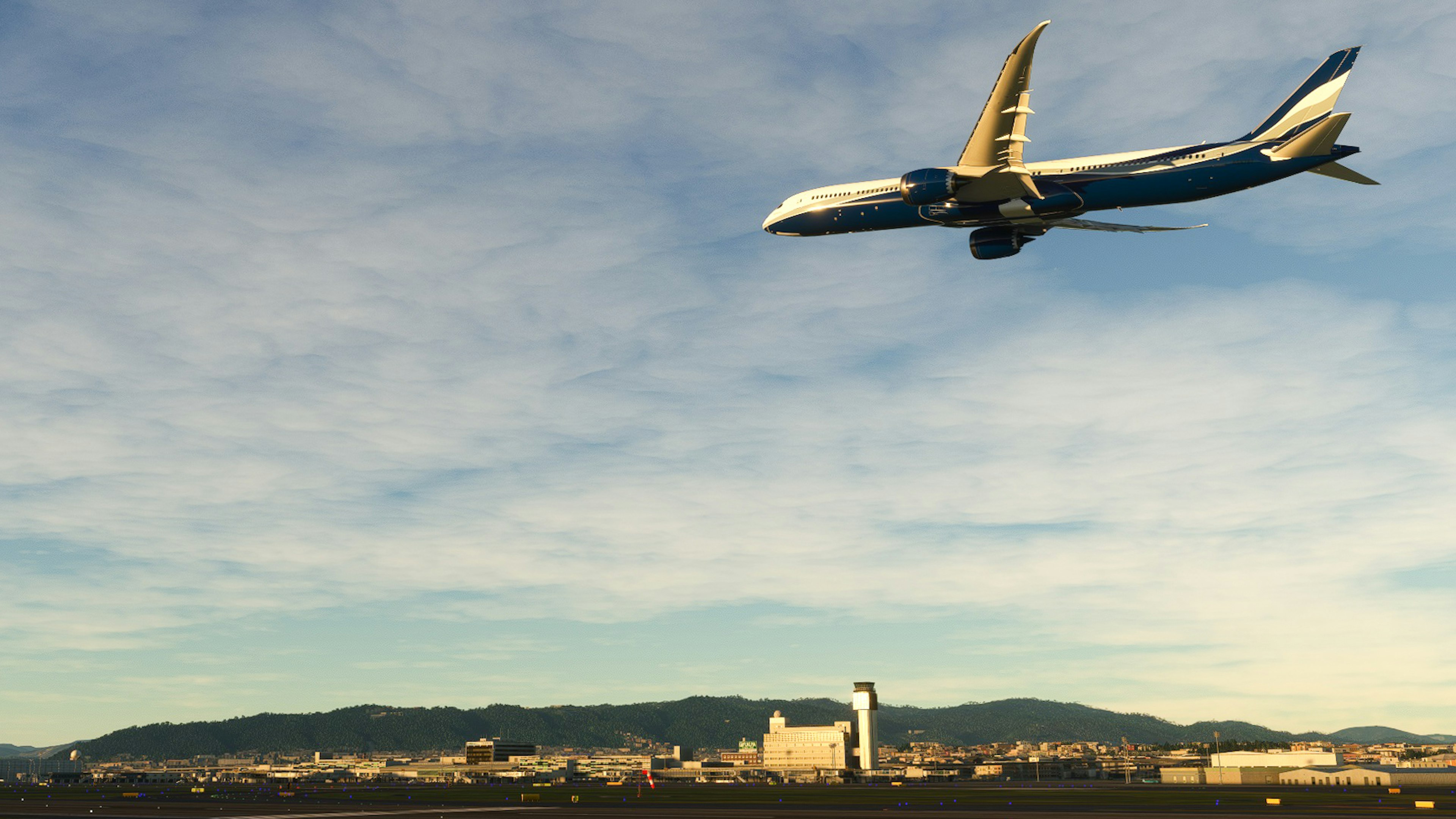 Blaues Flugzeug fliegt am Himmel über einer Landschaft