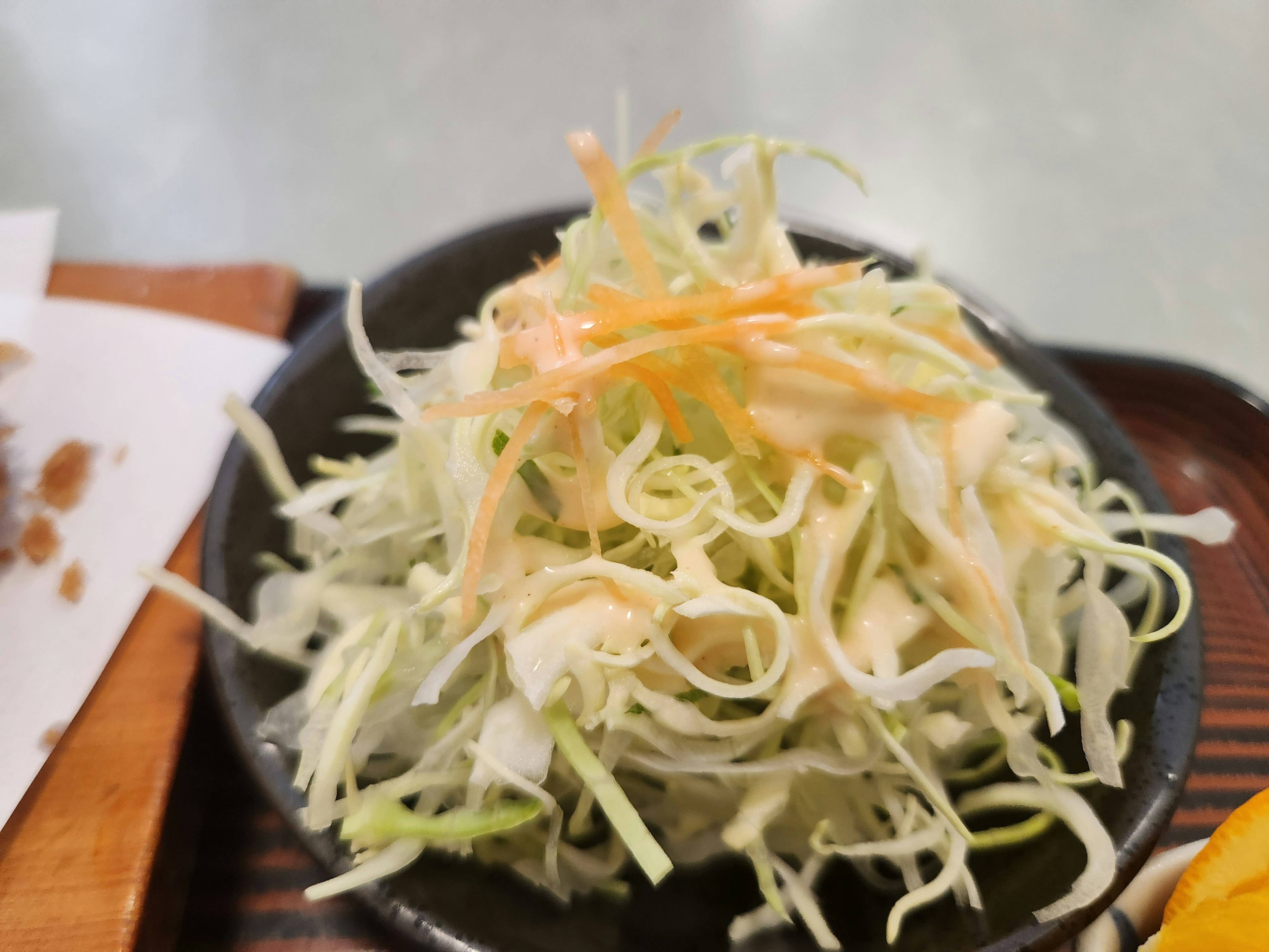 Salade de chou et de carotte râpés servie dans un bol noir