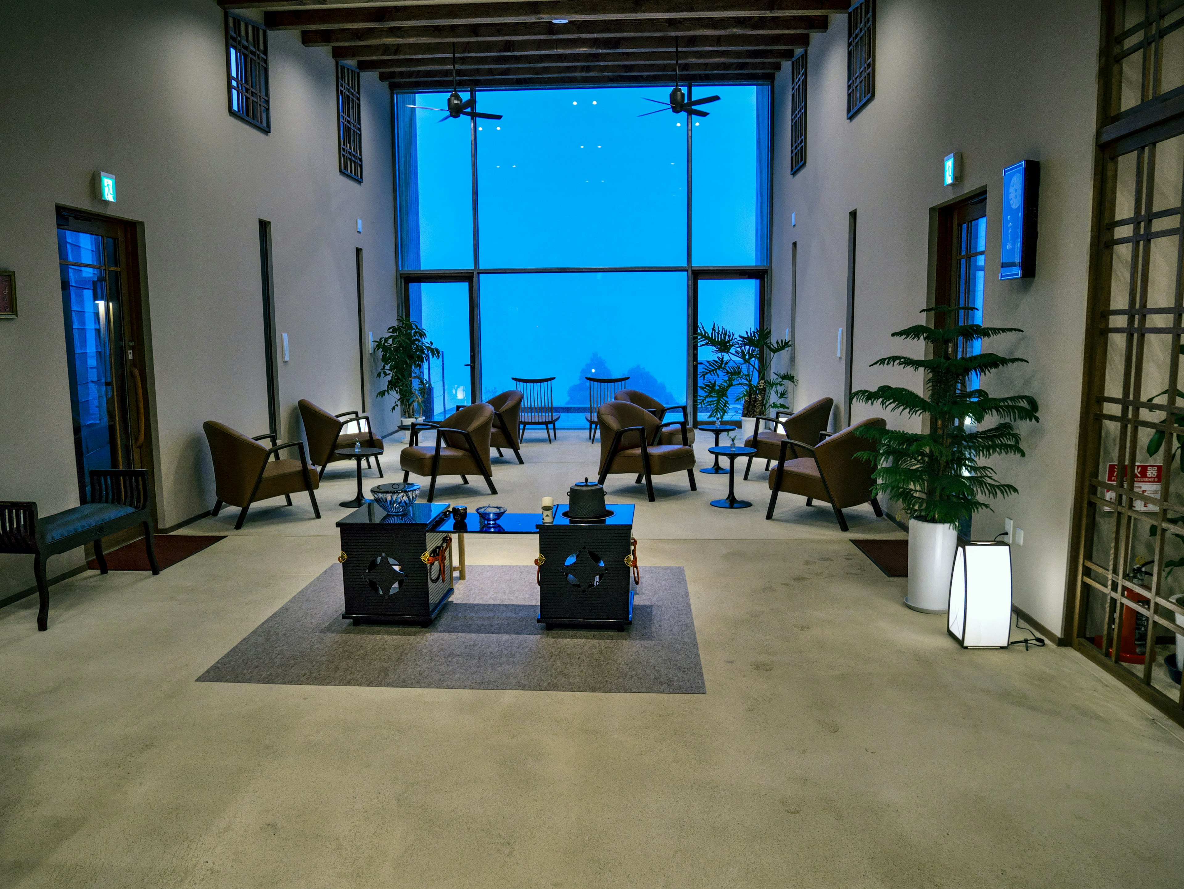 Interno moderno di un lobby con finestre blu sedie e tavoli disposti ordinatamente