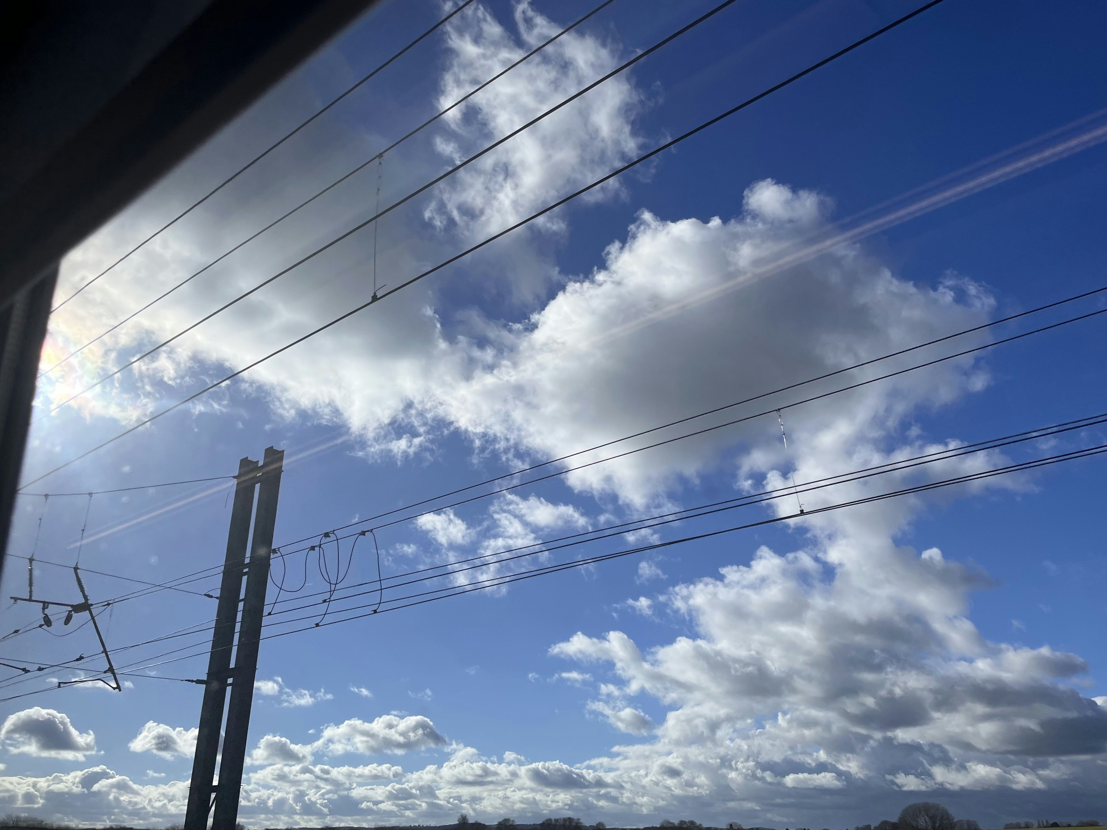 青空と白い雲が広がる風景 電線のある鉄道の風景