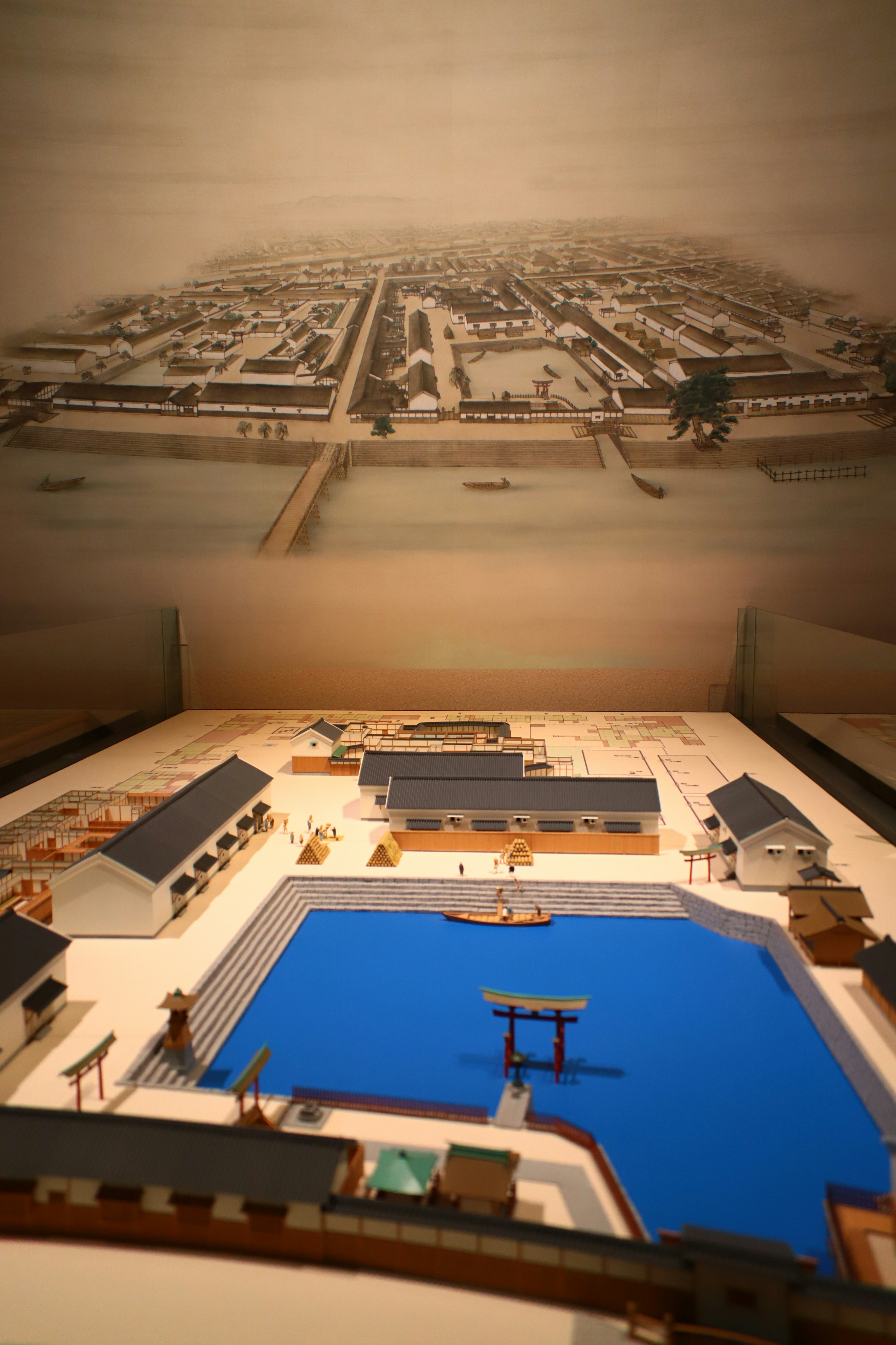 Model of a historical town with a blue water area and buildings