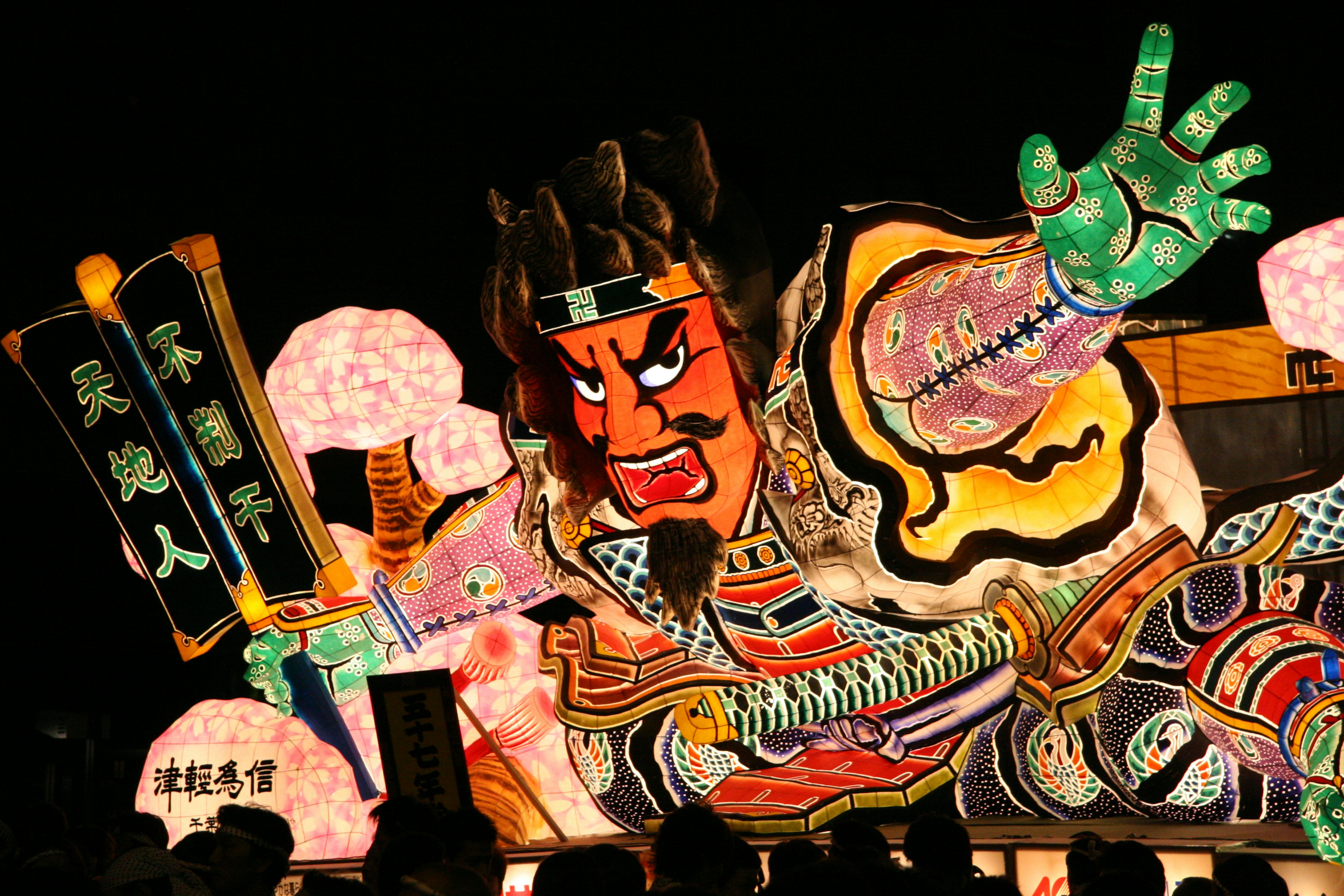 Large figure of a person holding a colorful festival lantern