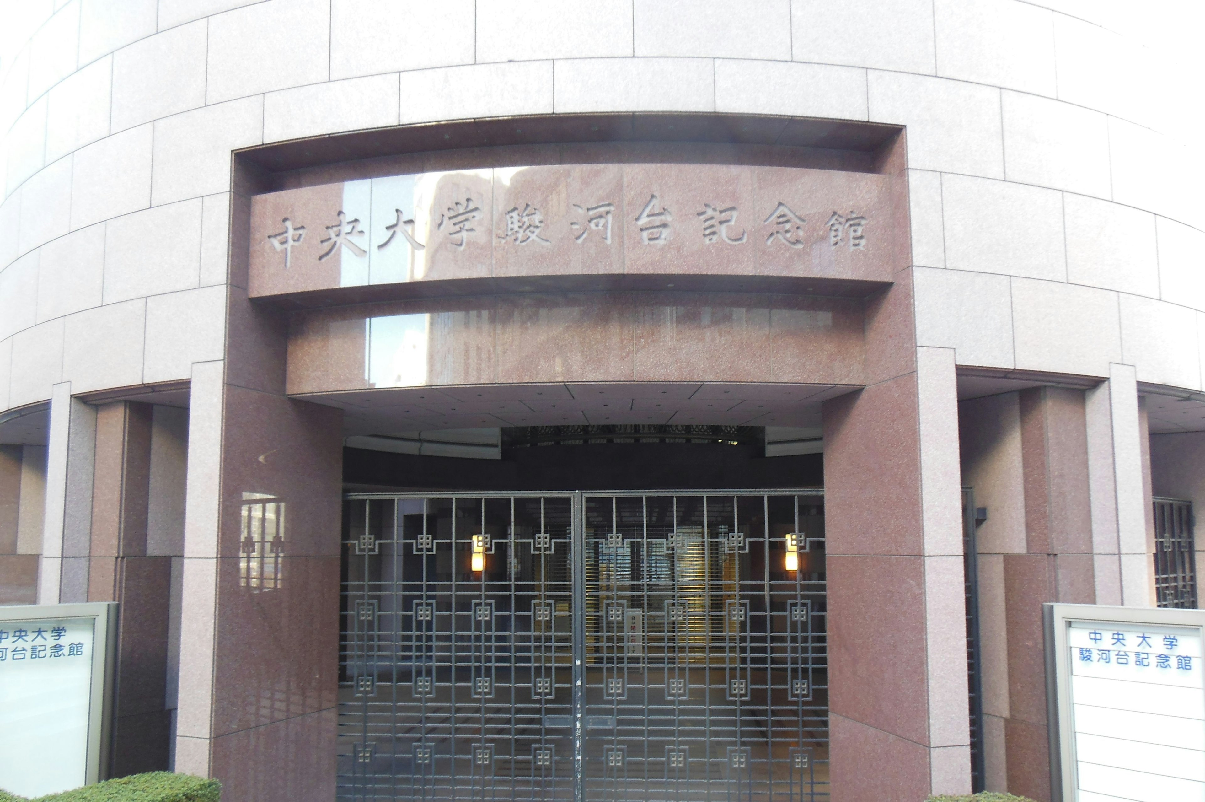 Entrance with metal gate and exterior of a high-rise building