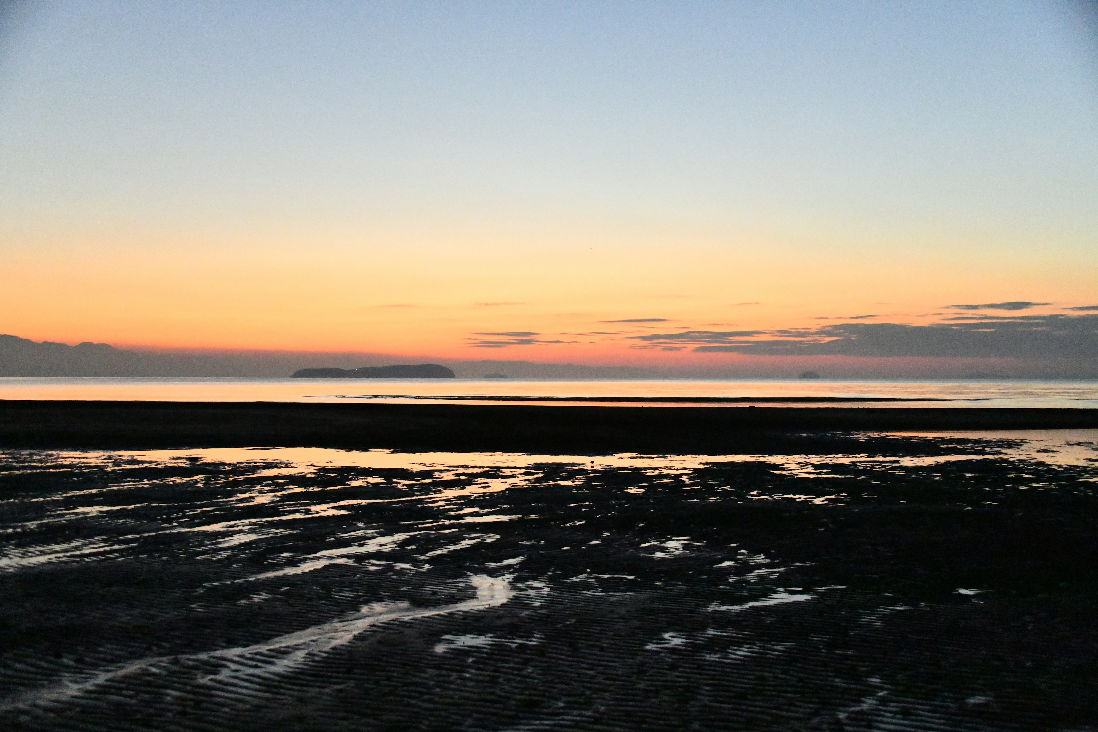 Escena de playa tranquila con un vibrante atardecer