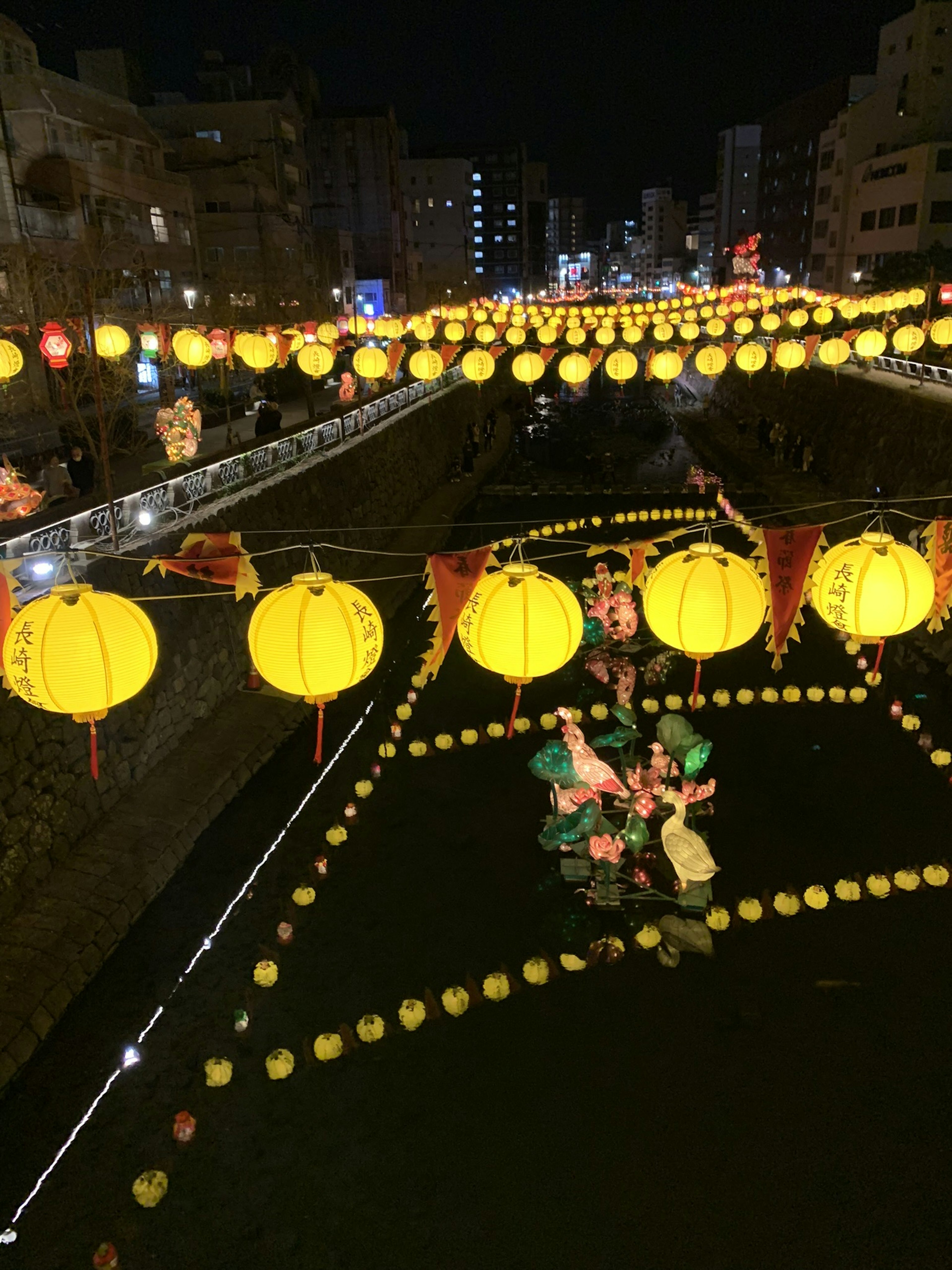 Lanternes et décorations de festival flottant sur une rivière la nuit